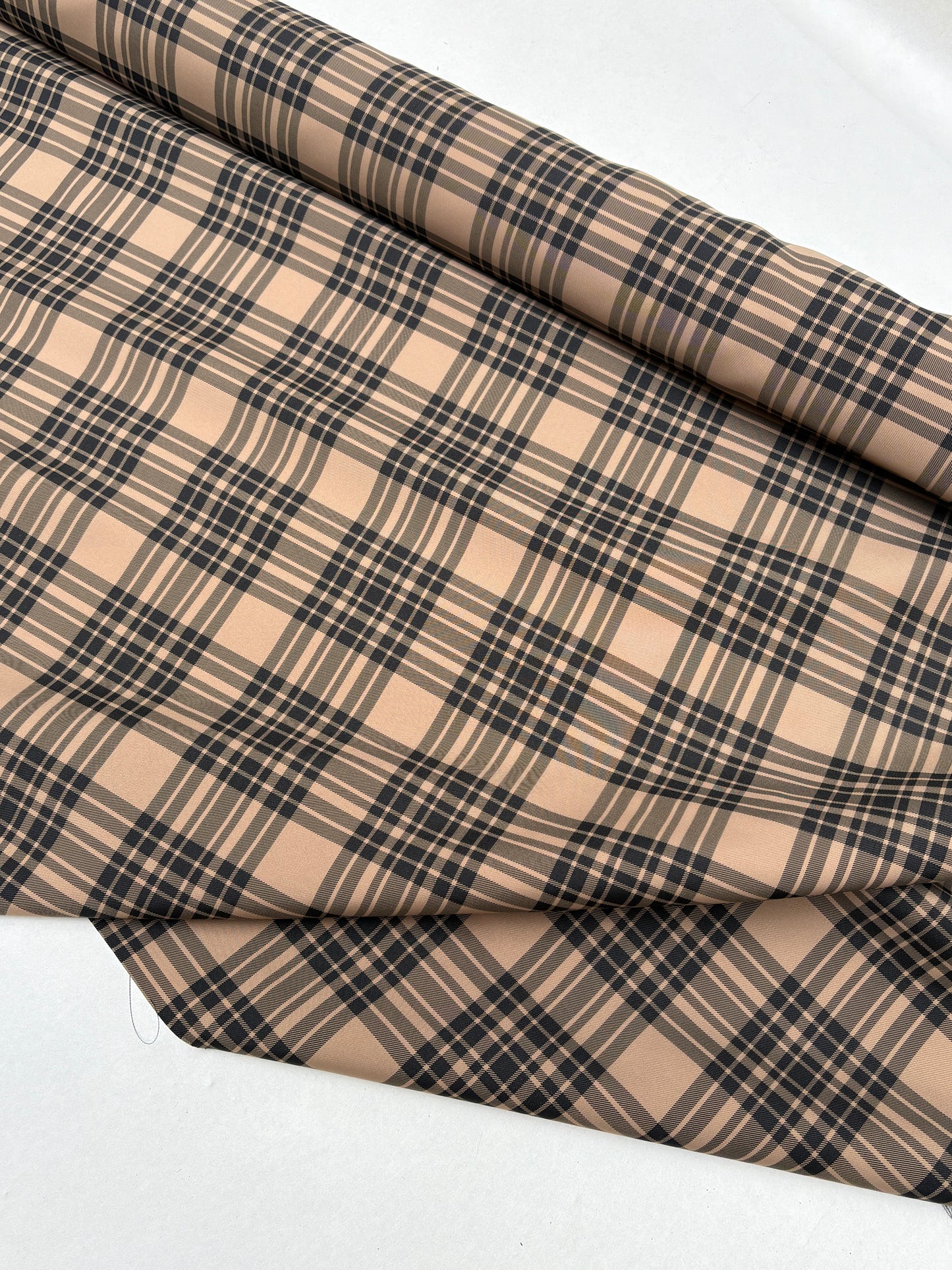 End-of-roll fabric with a tartan-like pattern in close-up.