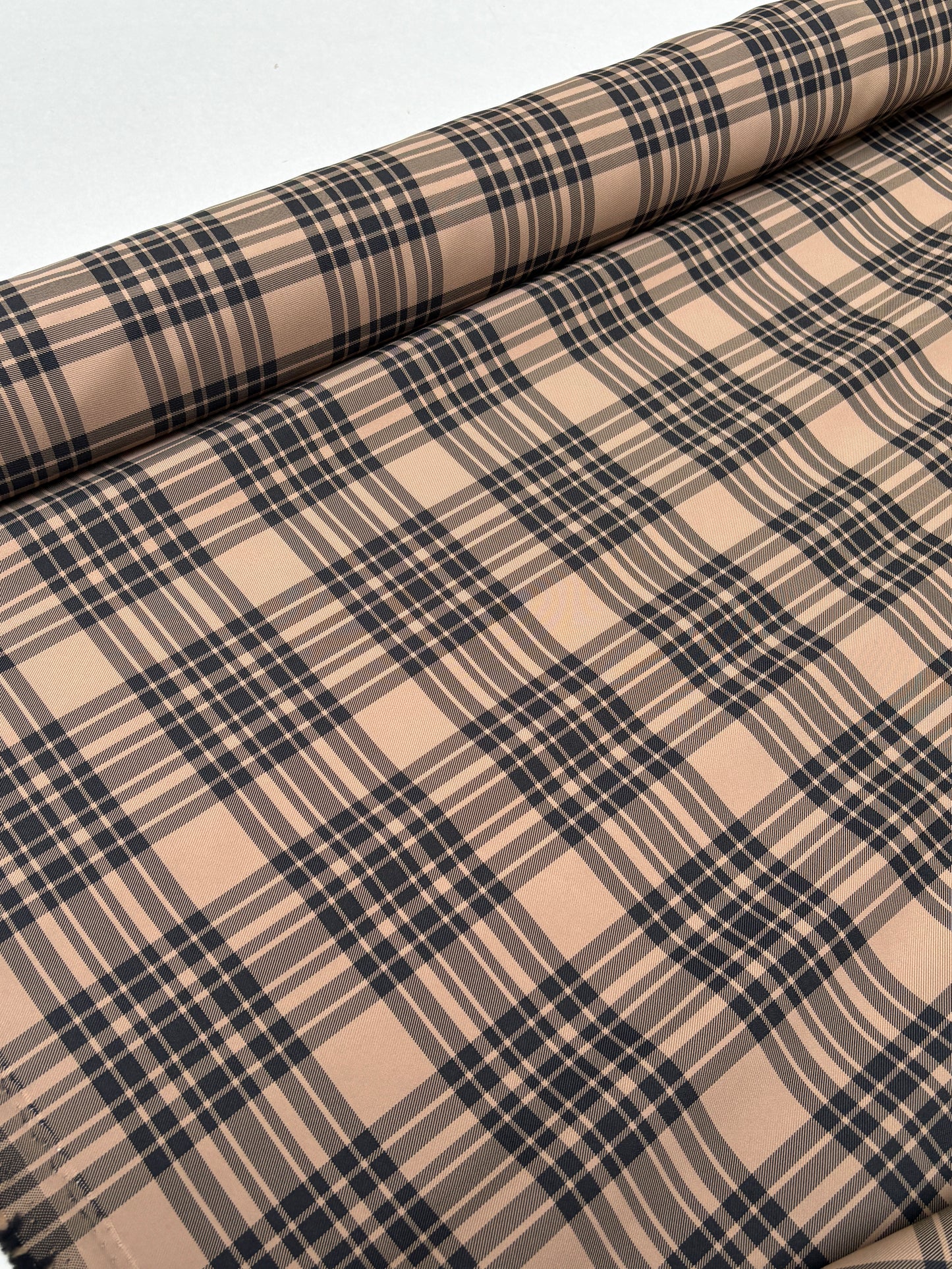 Tartan-like checked fabric captured in a close roll-end view.