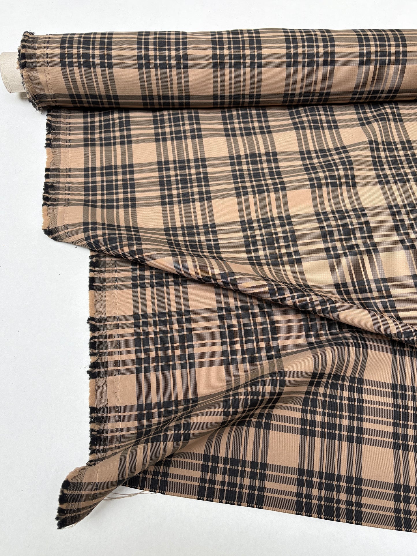 Tartan-like checked fabric captured in a close roll-end view.