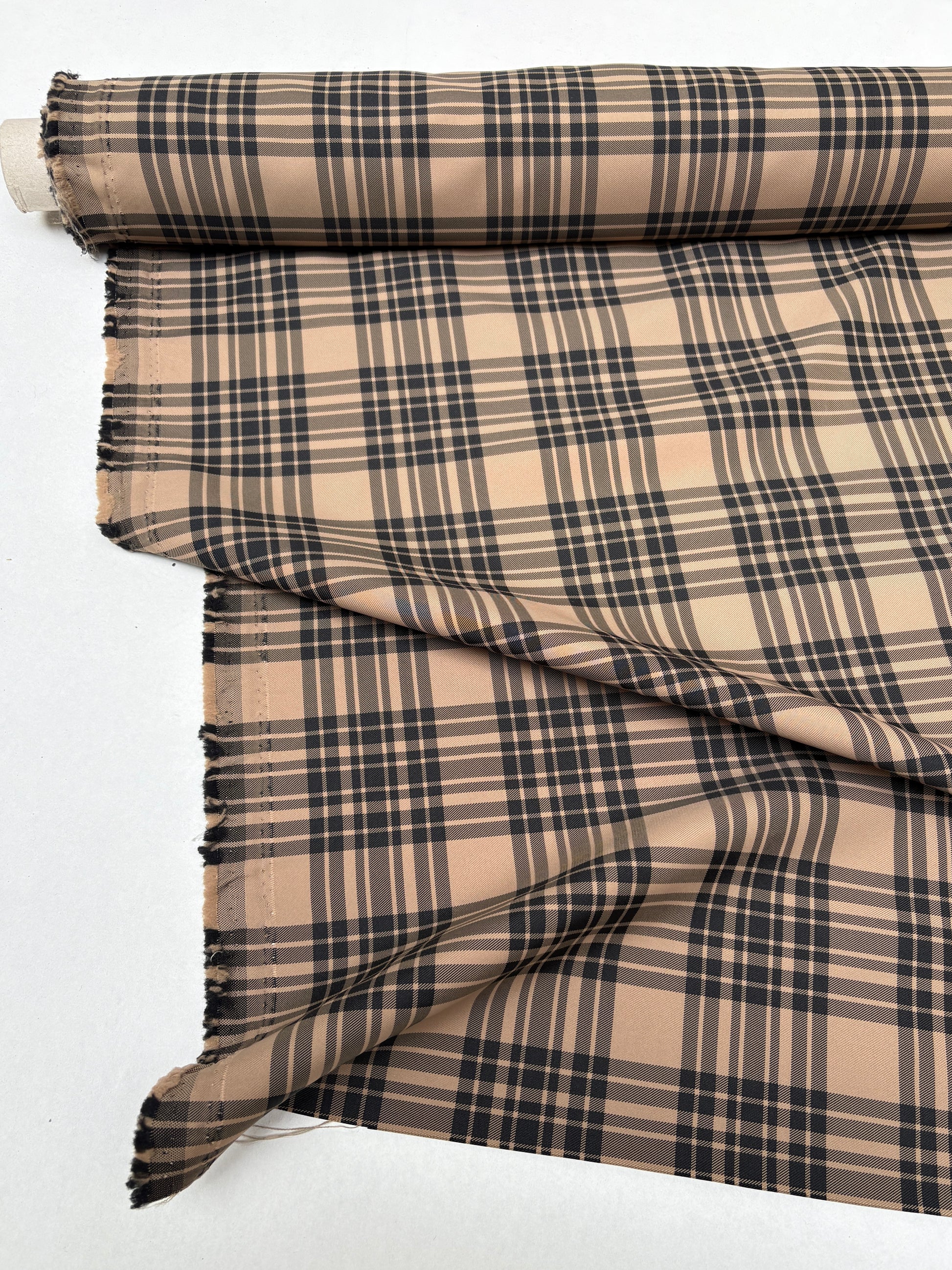 Tartan-like checked fabric captured in a close roll-end view.