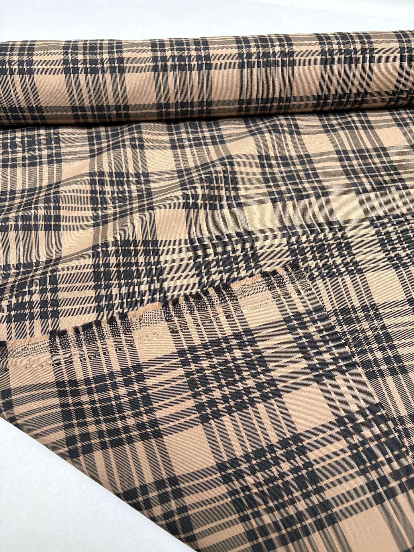Tartan-like patterned fabric shown at the end of the roll.