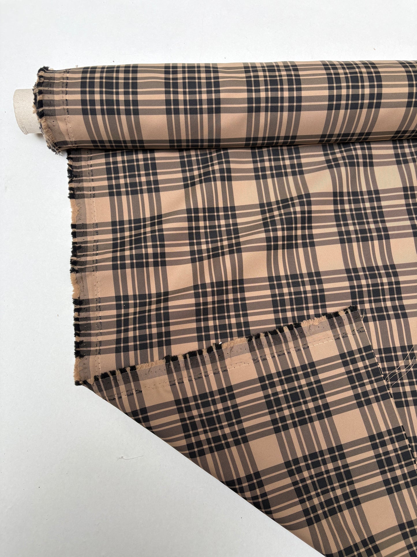Tartan-inspired checked fabric displayed from the end of the roll.