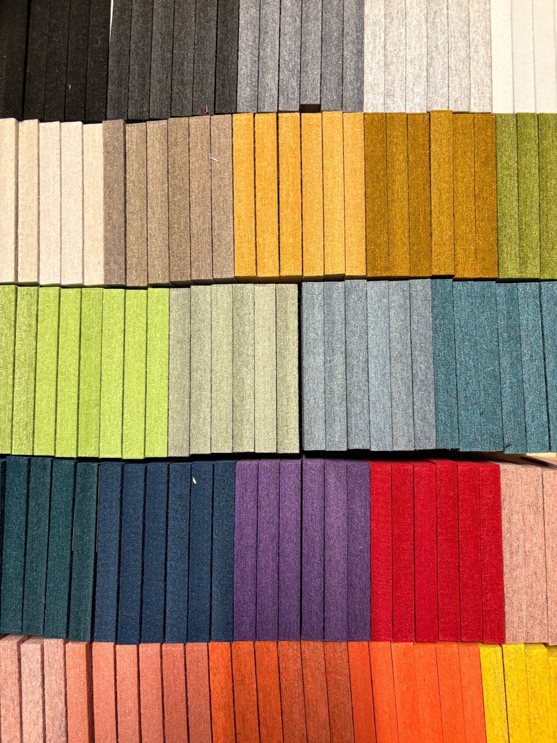 Bright square felt tiles are arranged in tall stacked columns