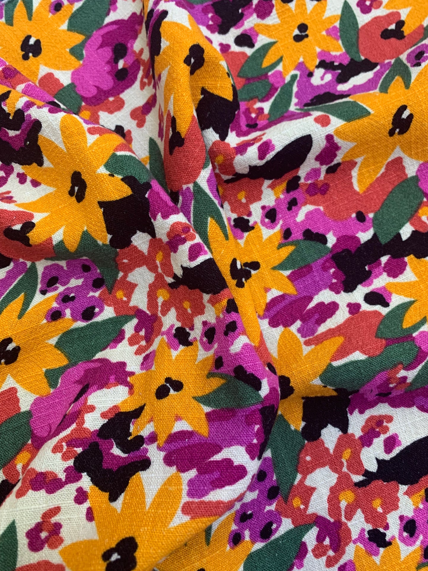 Bright patterned fabric shows yellow flowers and green leaves