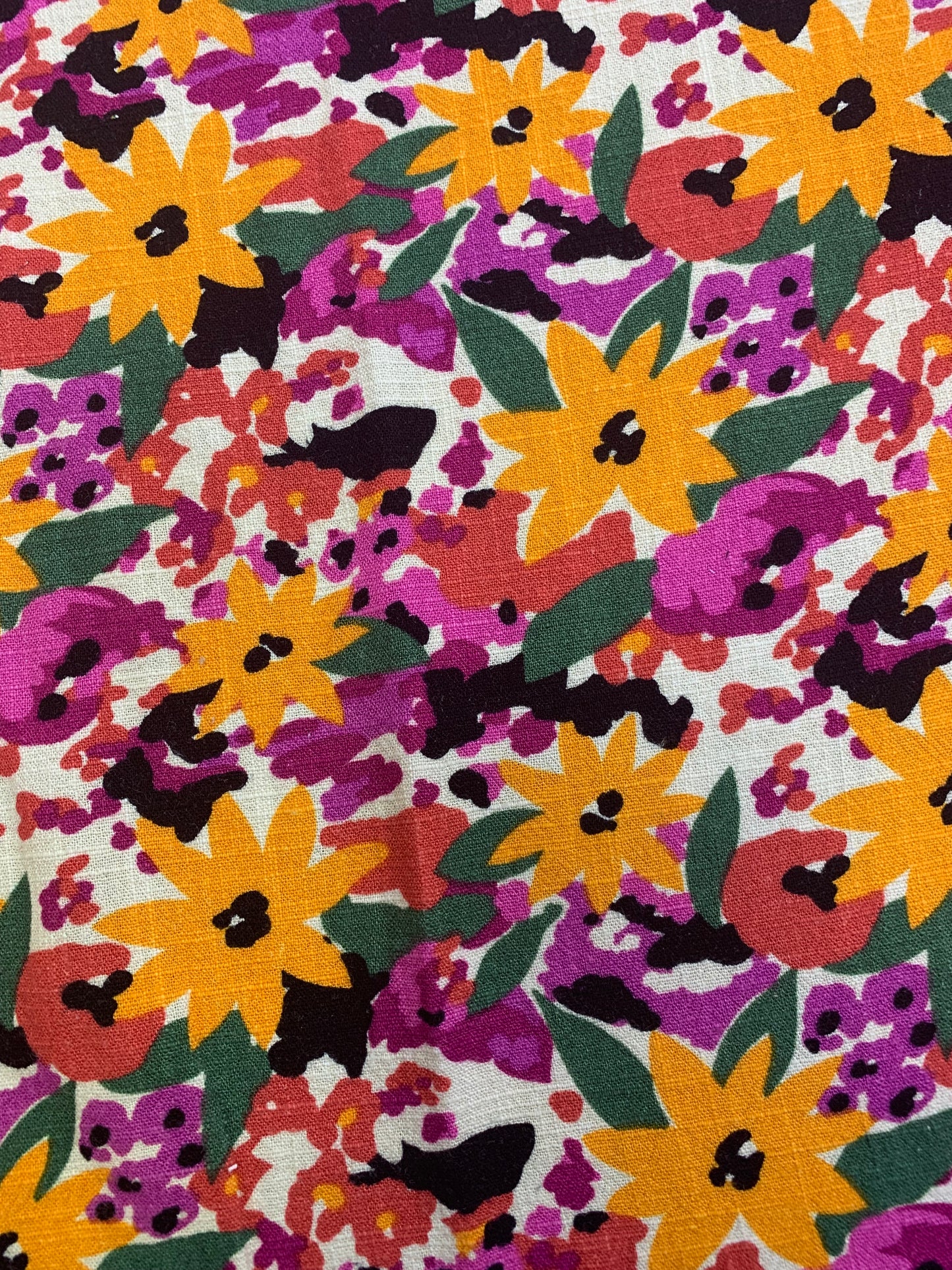 Floral fabric in yellow, purple, and red fills the image