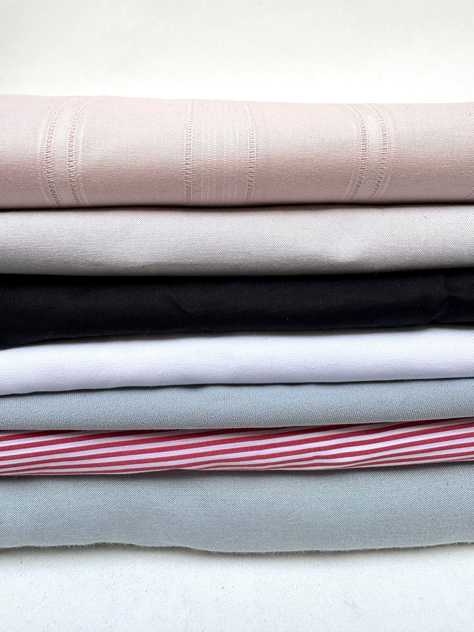 Folded fabric pieces in mixed colours are shown together