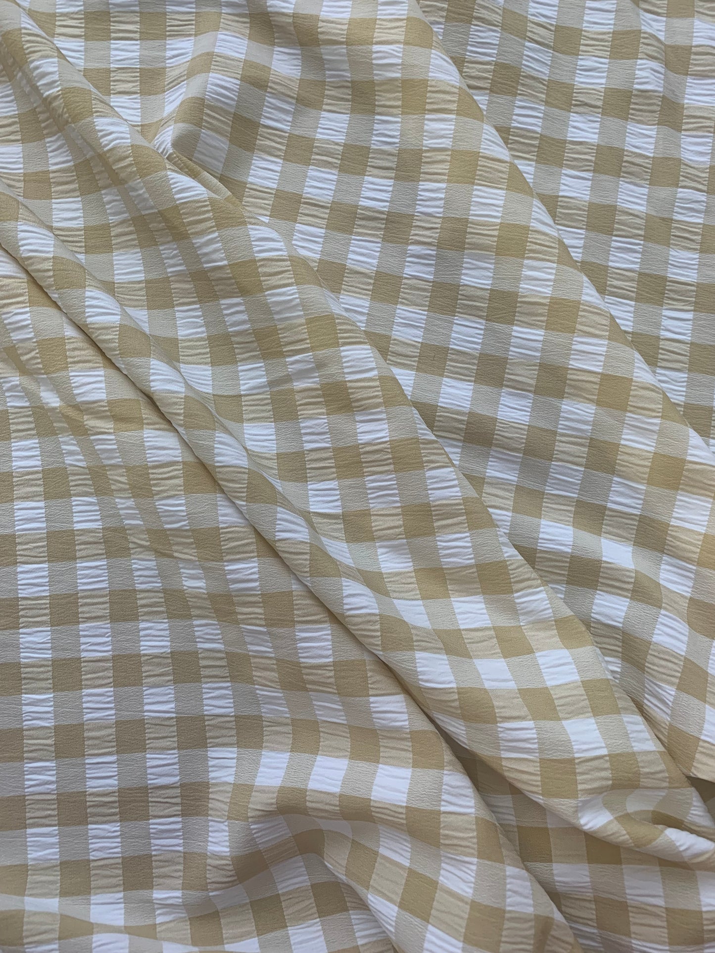 Checked beige and white fabric is shown in close-up