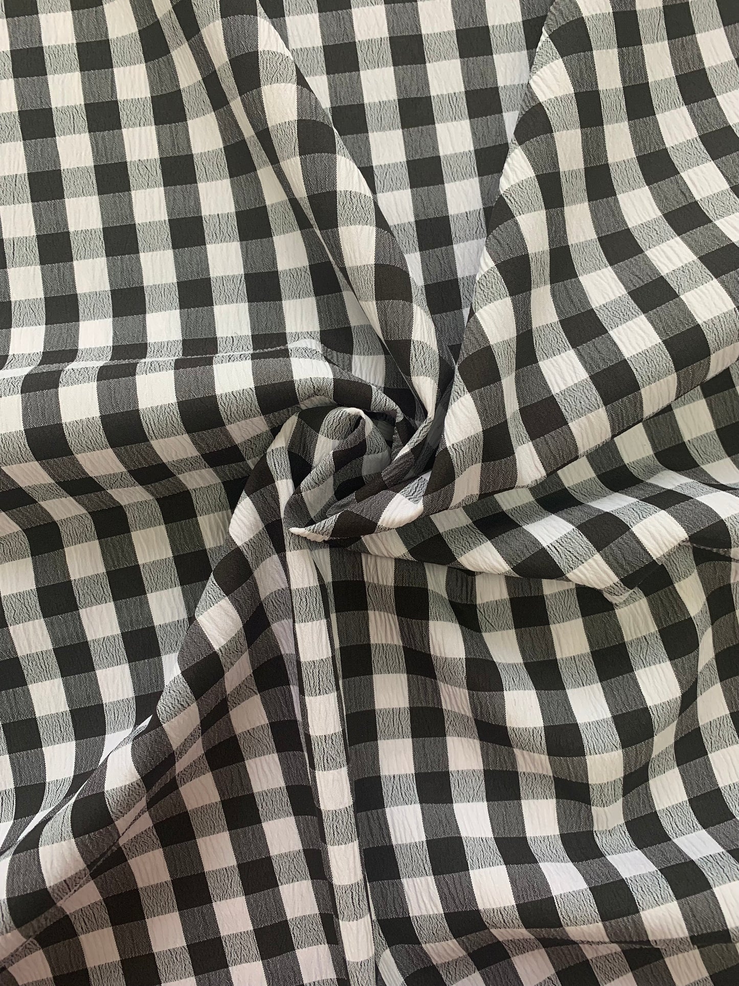 white and black checked fabric is gathered into soft folds.