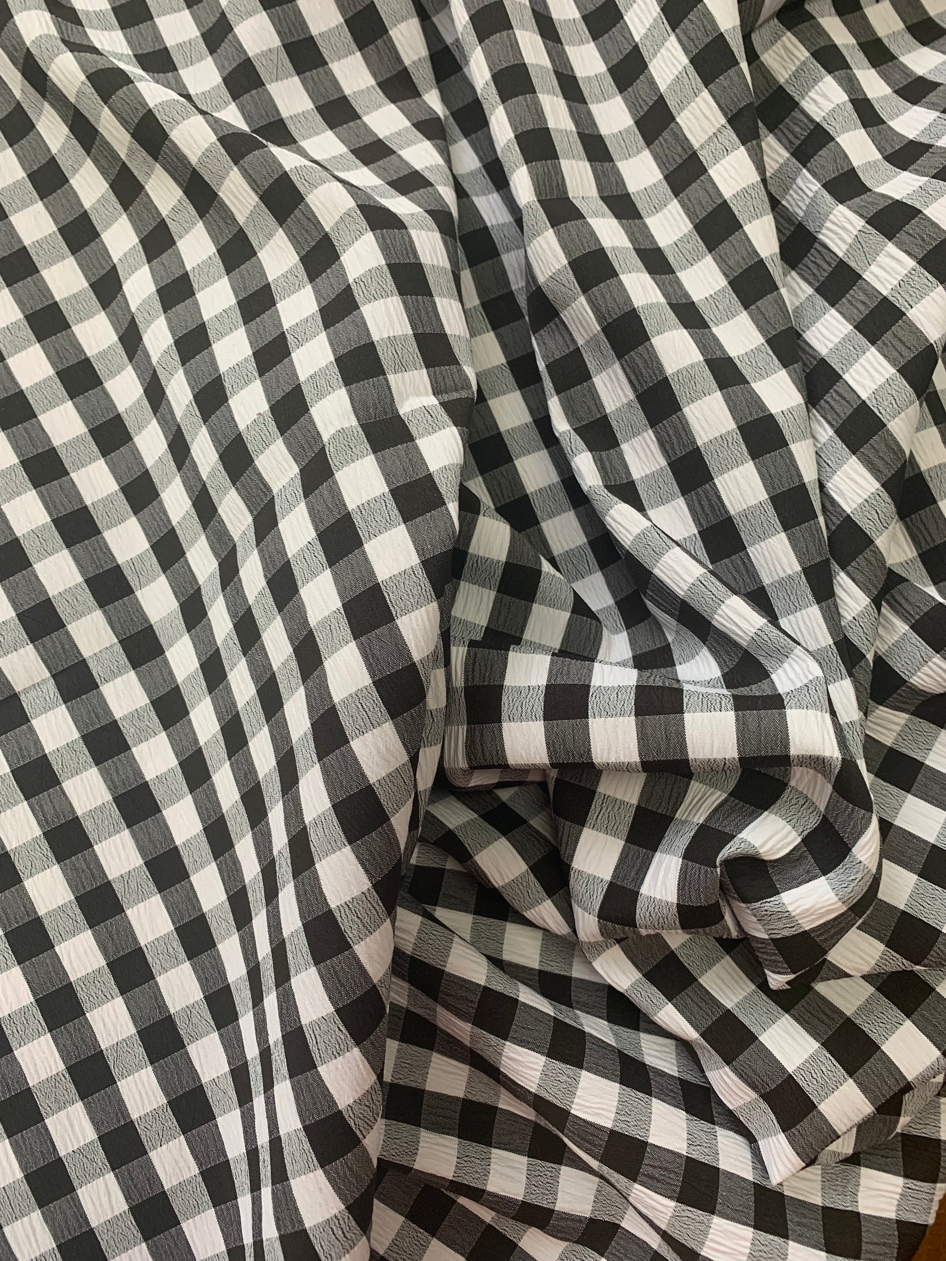 Black and white gingham fabric is shown in close-up