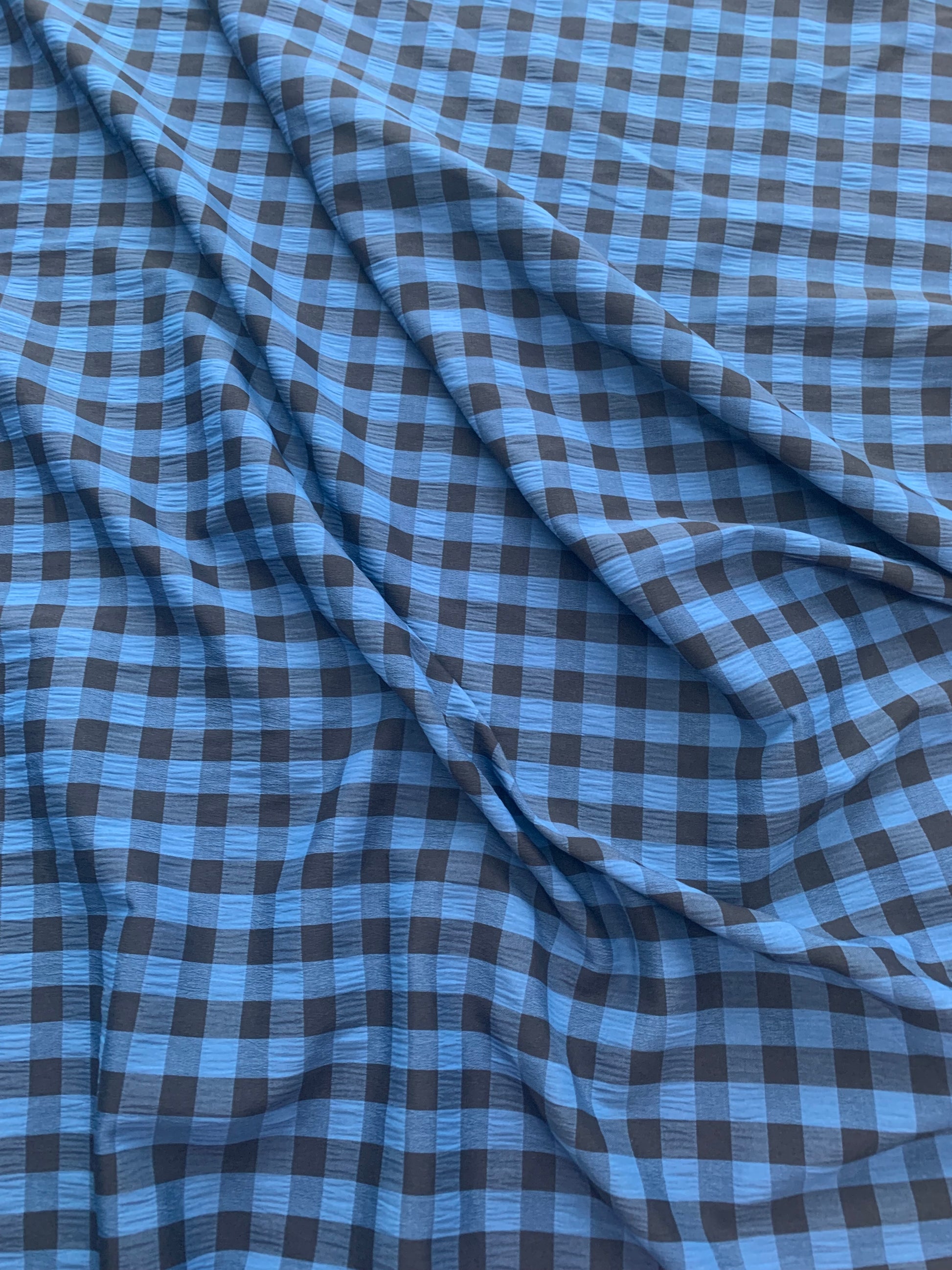 Folded blue check fabric fills the image with texture