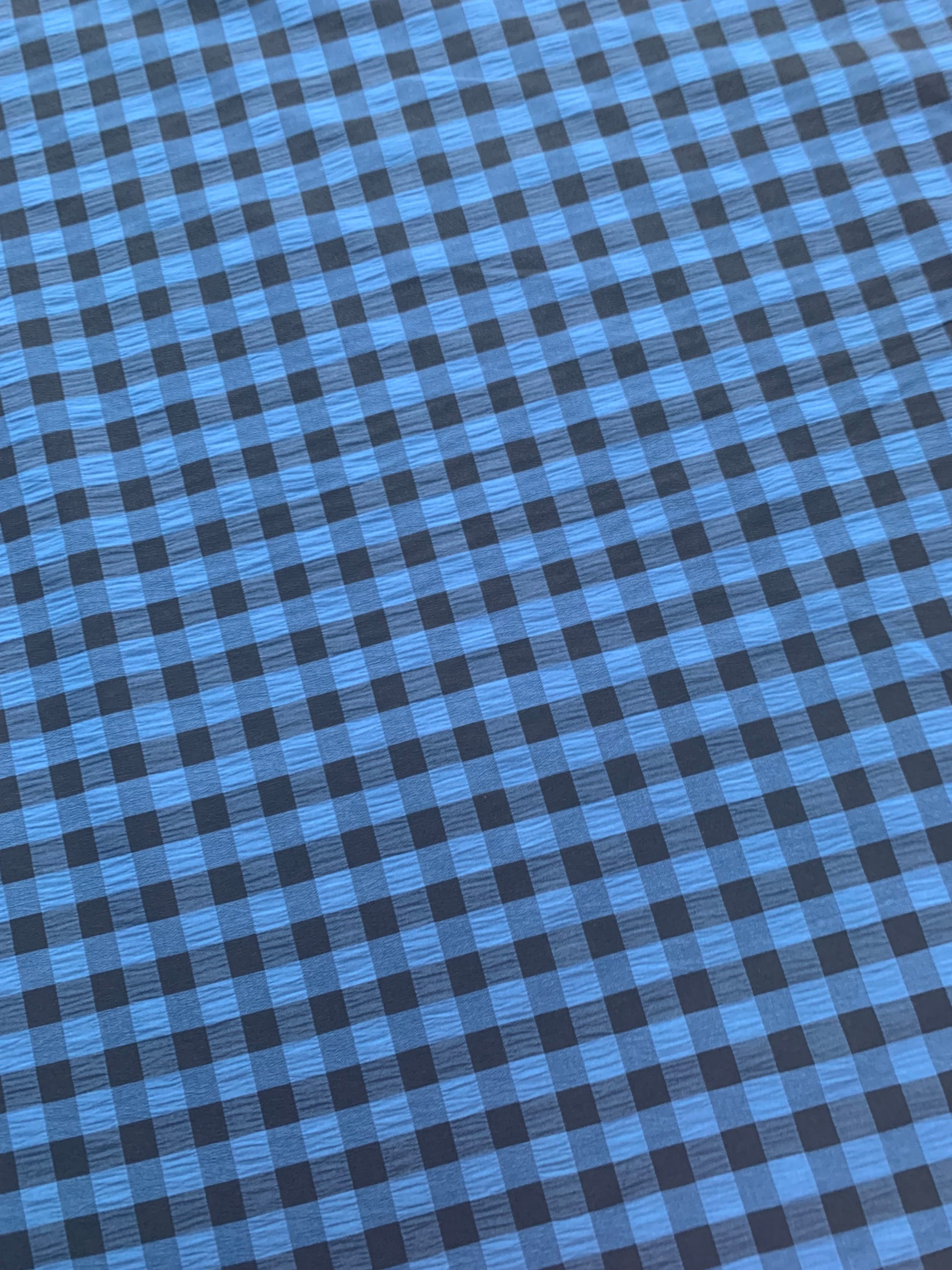 Black and blue gingham fabric is shown in close-up