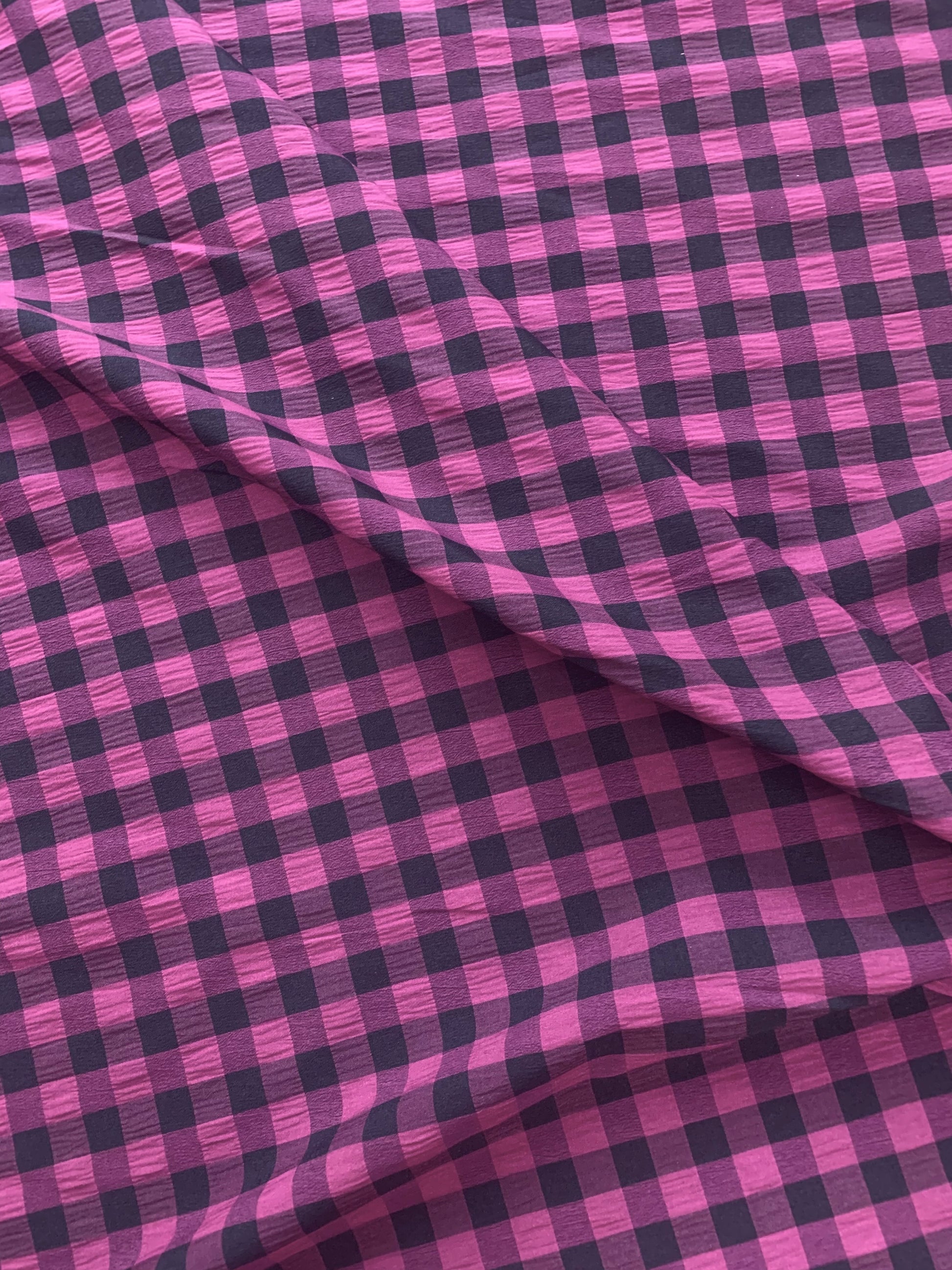 Purple and black checked fabric is gathered into soft folds