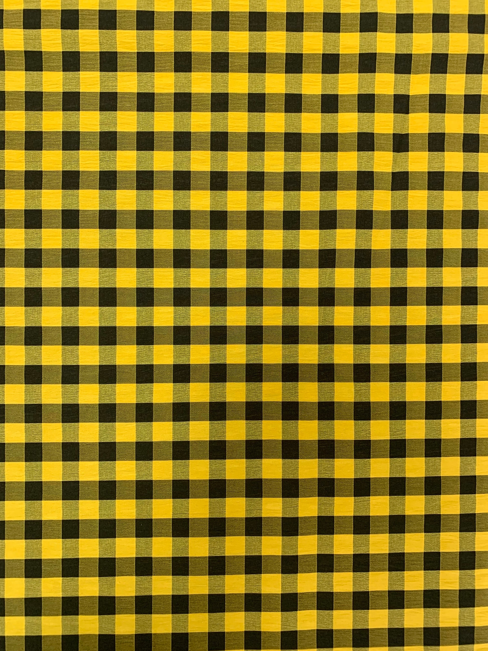 Black and yellow gingham fabric is shown in close-up