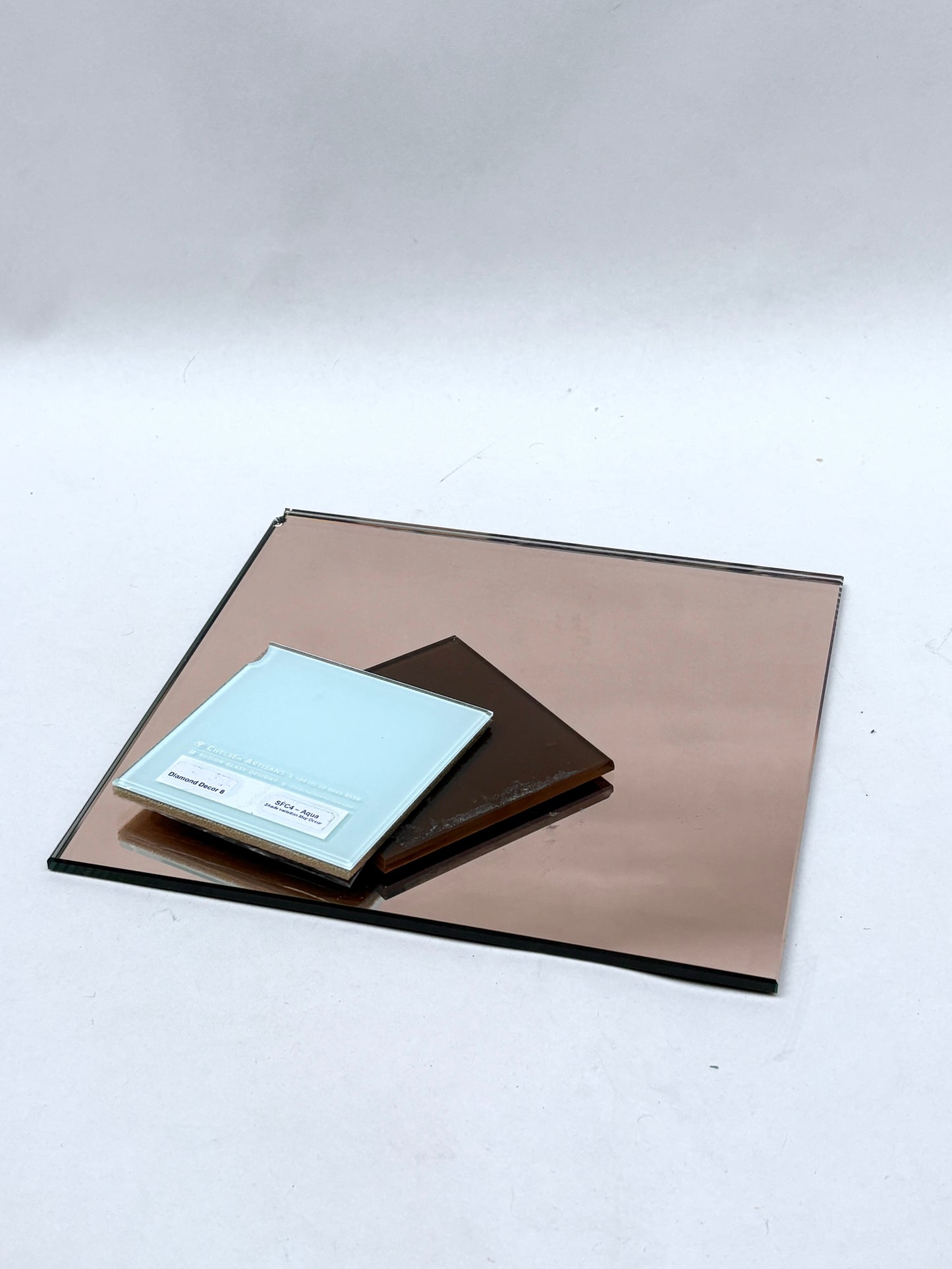 Collection of coloured glass and reflective mirror offcuts stacked together