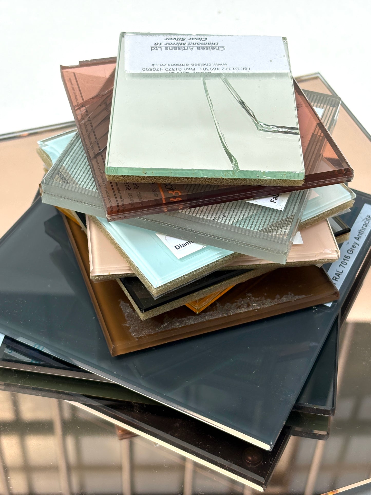 Close-up of an assorted tinted glass and mirror pieces on a white surface