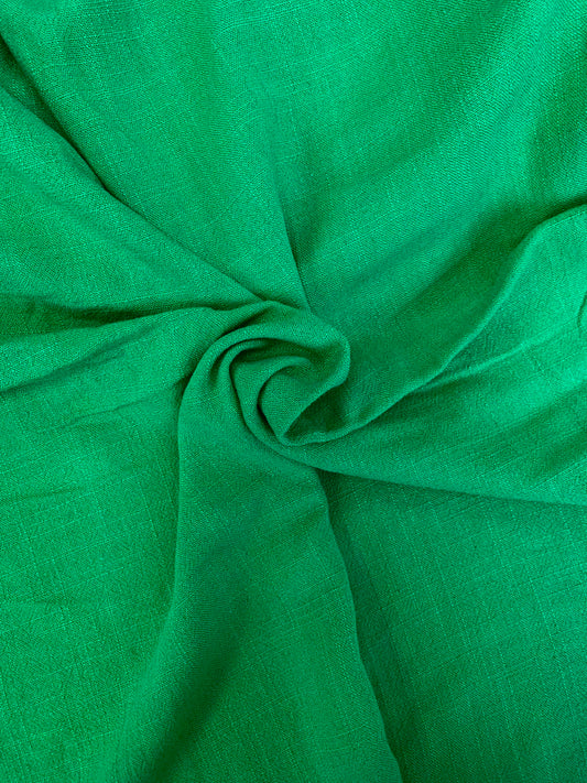 A close fabric study of green cloth shaped in loose folds.