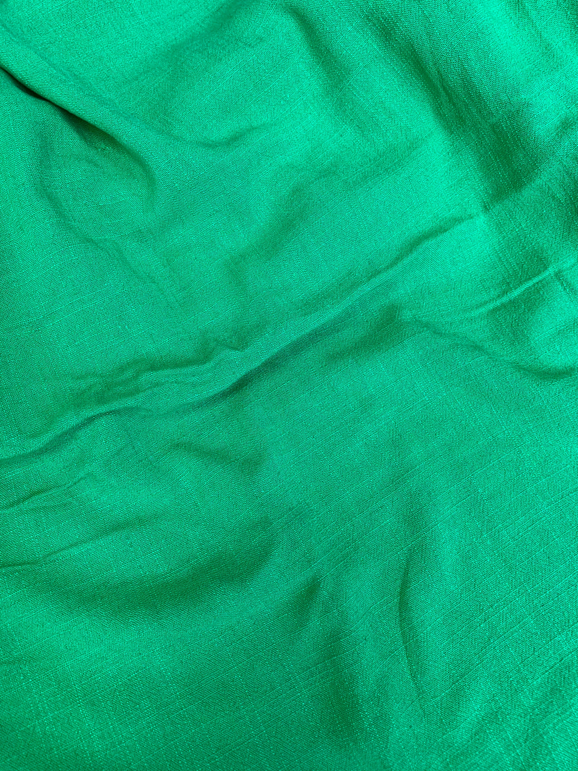 Detailed surface shot of green sand-washed cloth.