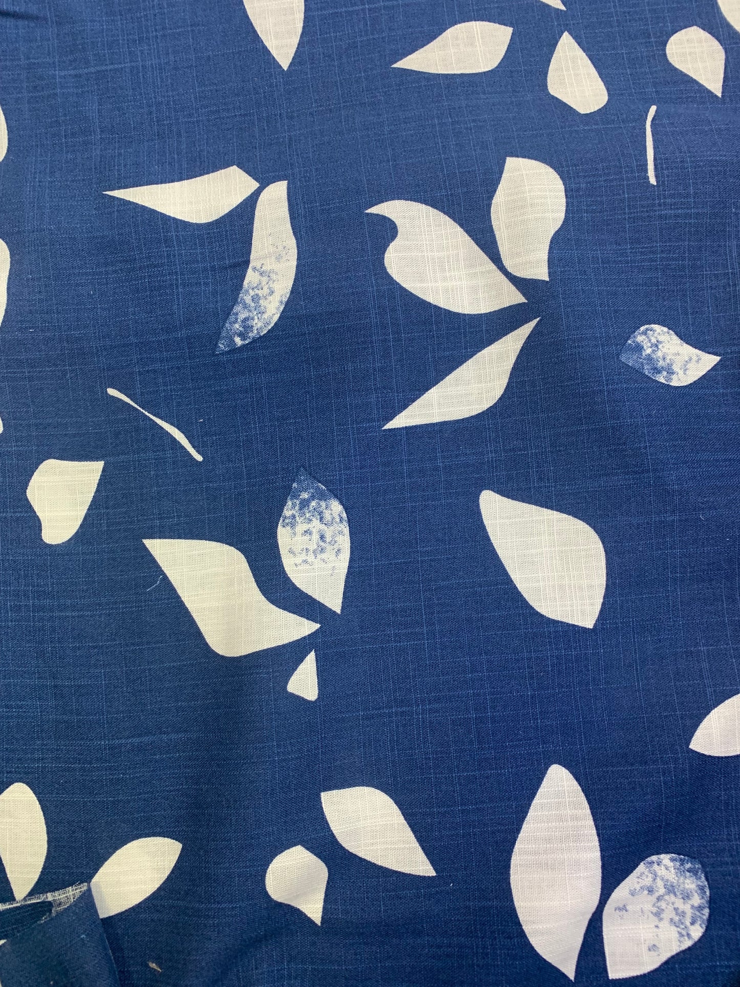 Navy fabric is shown in close-up with white patterns