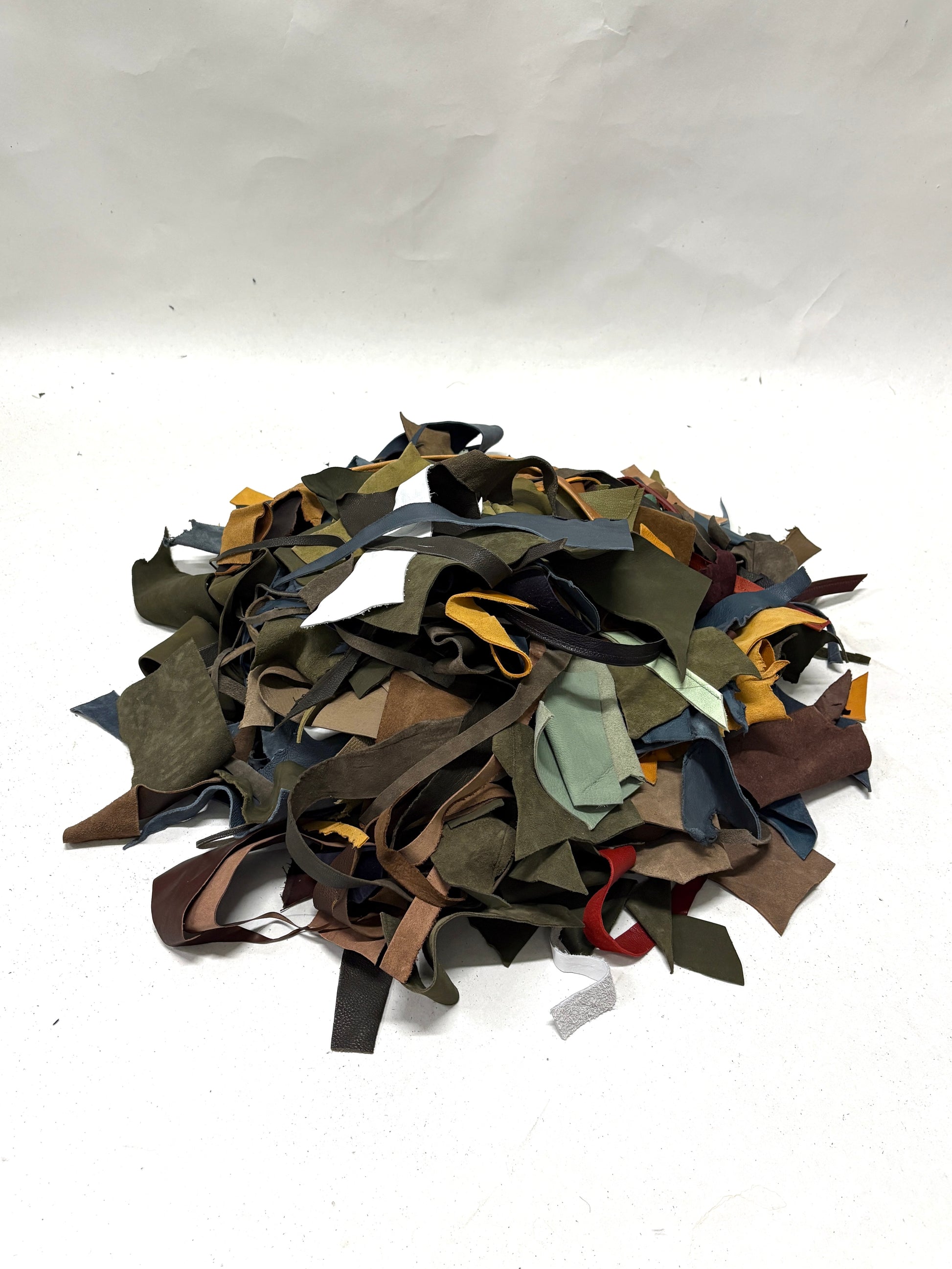 Pile of multicolored leather offcuts on a white background