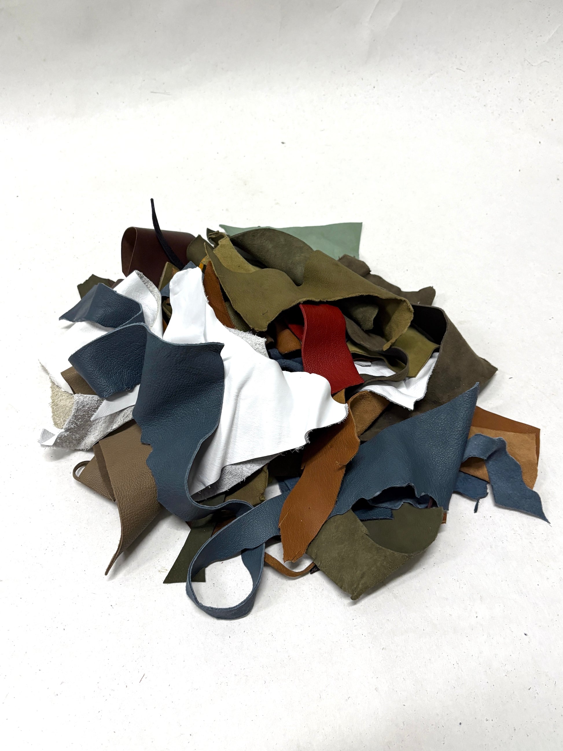 Collection of leather offcuts in various colors on a white background