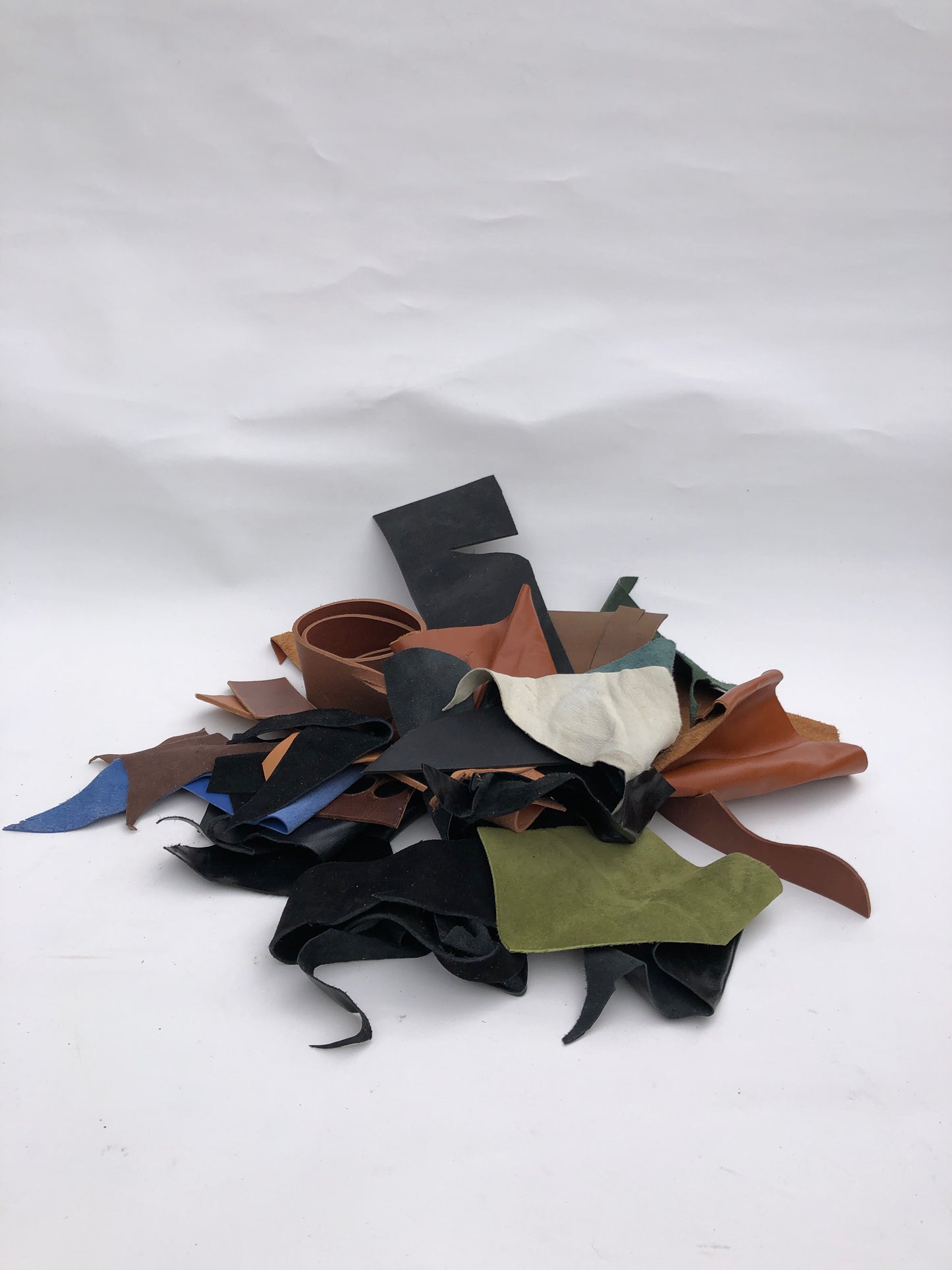 Collection of leather offcuts in various colors on a white background