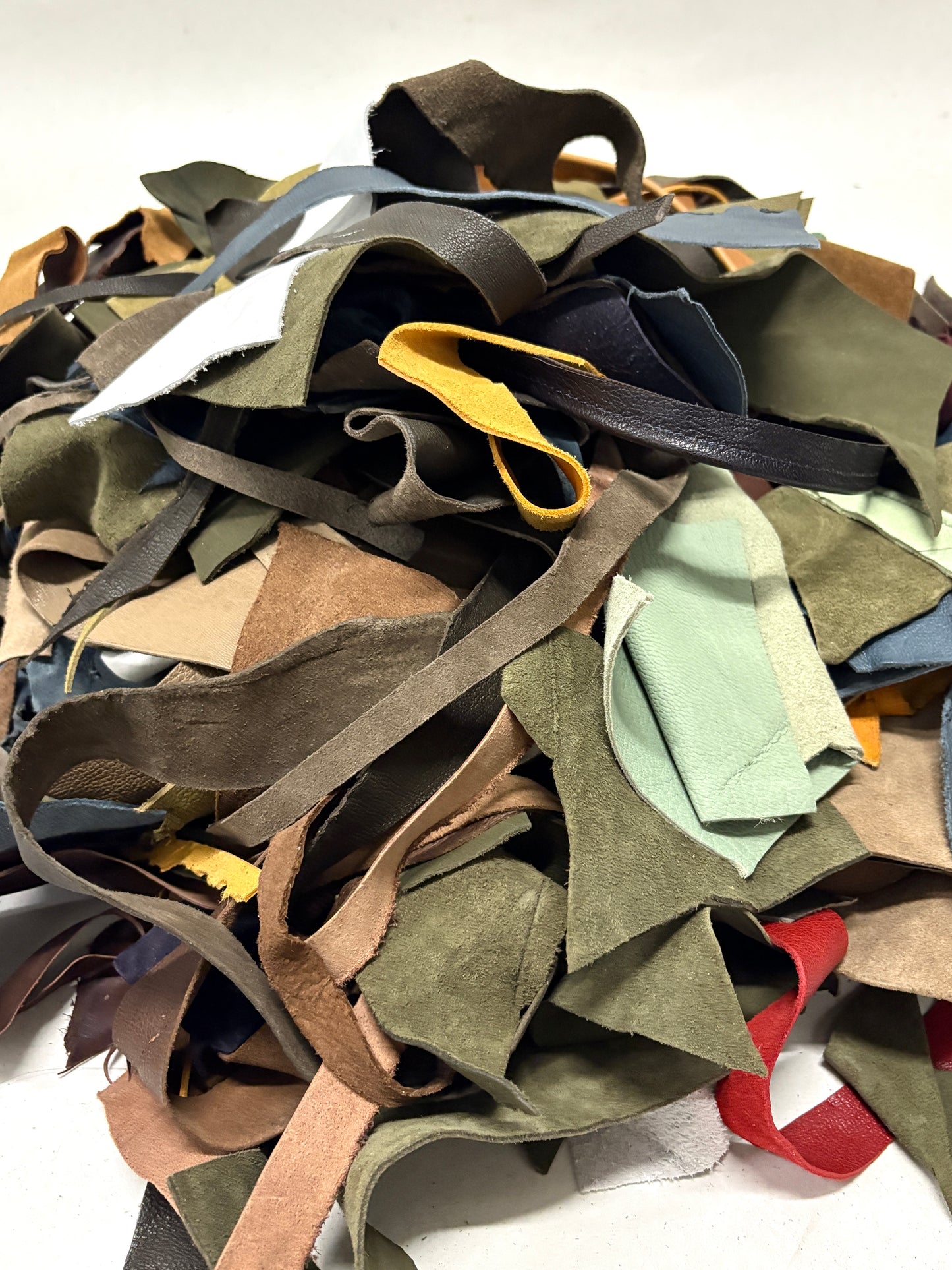 Pile of multicolored leather offcuts on a white background