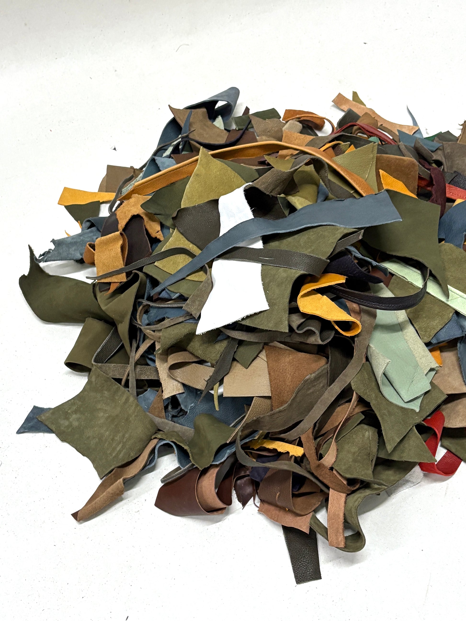 Pile of multicolored leather offcuts on a white background