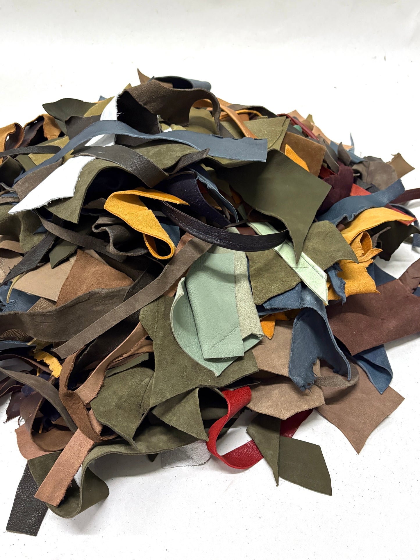 Pile of multicolored leather offcuts on a white background