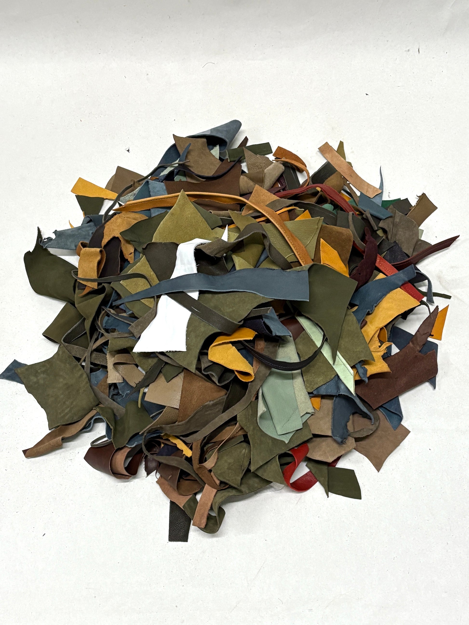 Pile of multicolored leather offcuts on a white background