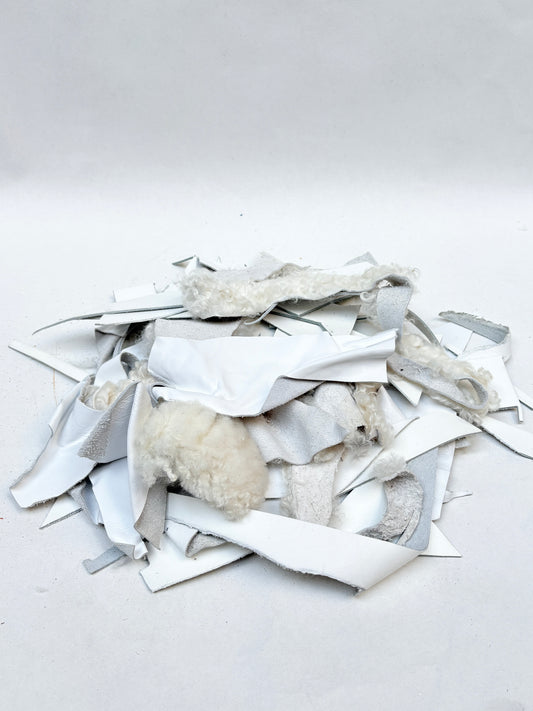 White material offcuts are piled on a white background