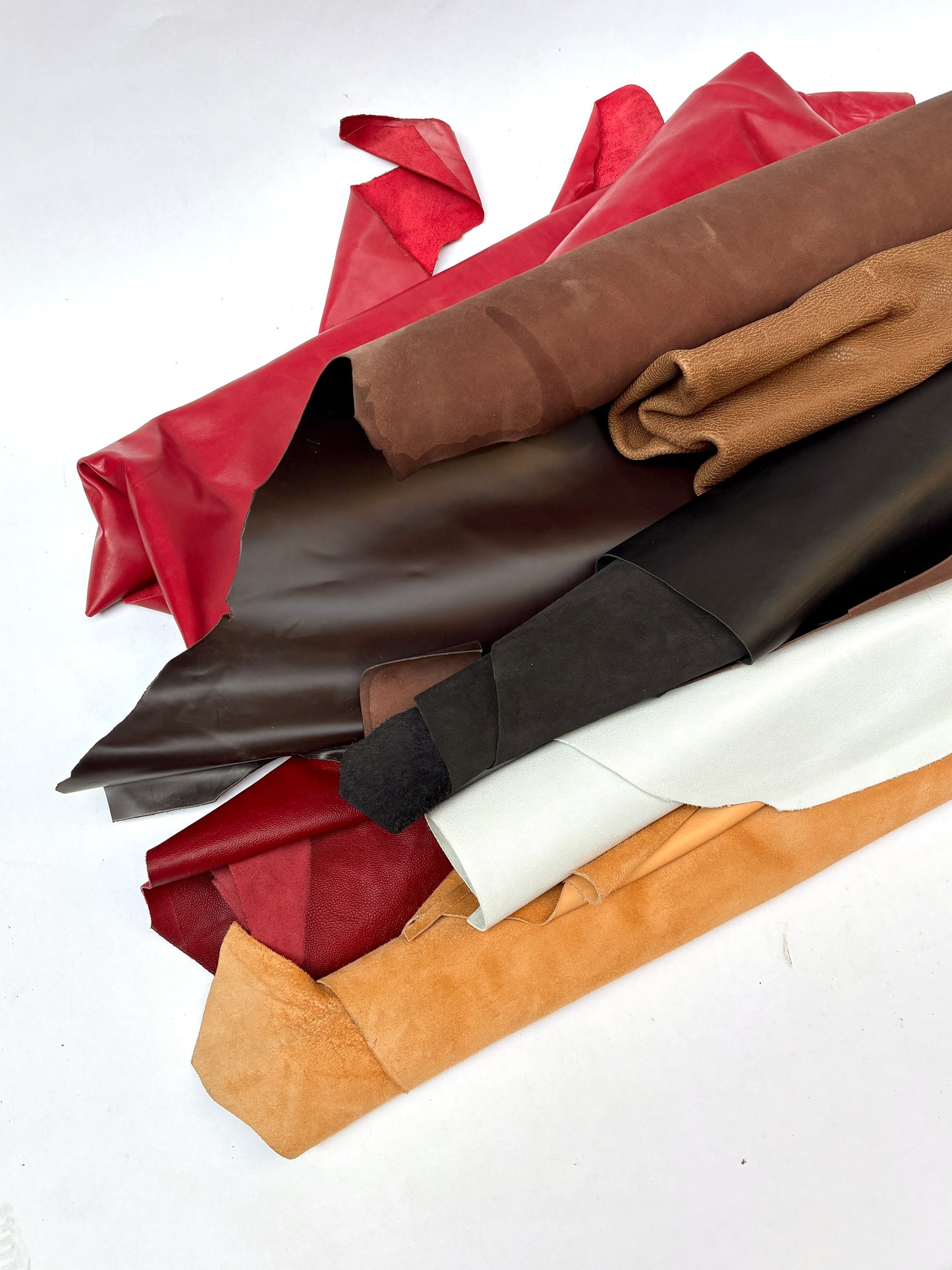 Stack of leather rolls in various colors on a white background