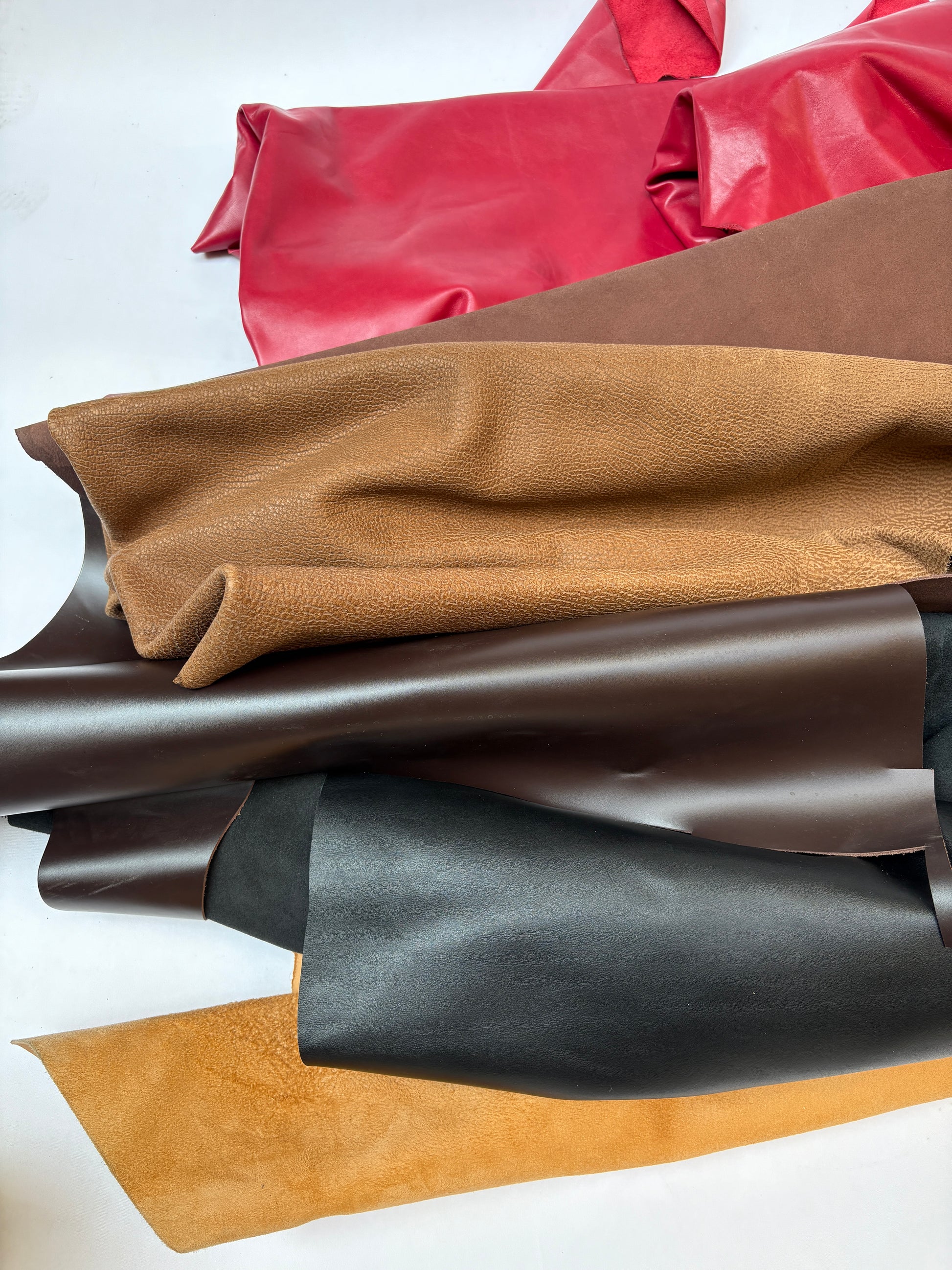 Rolls of leather in various colors on a white background