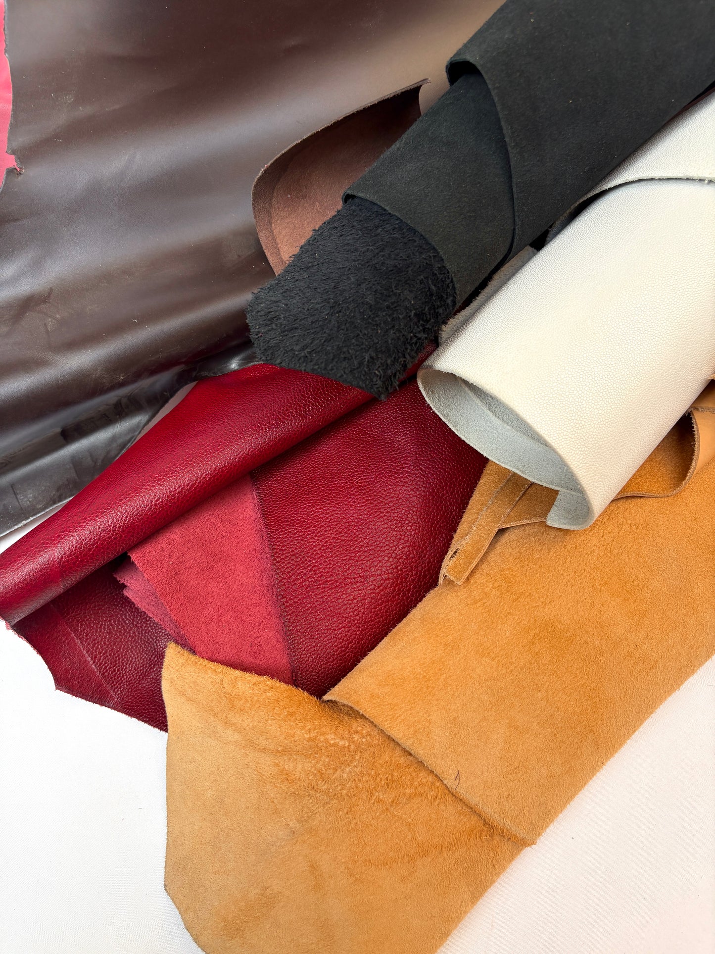 Close-up of rolls of leather in red, brown, black and beige