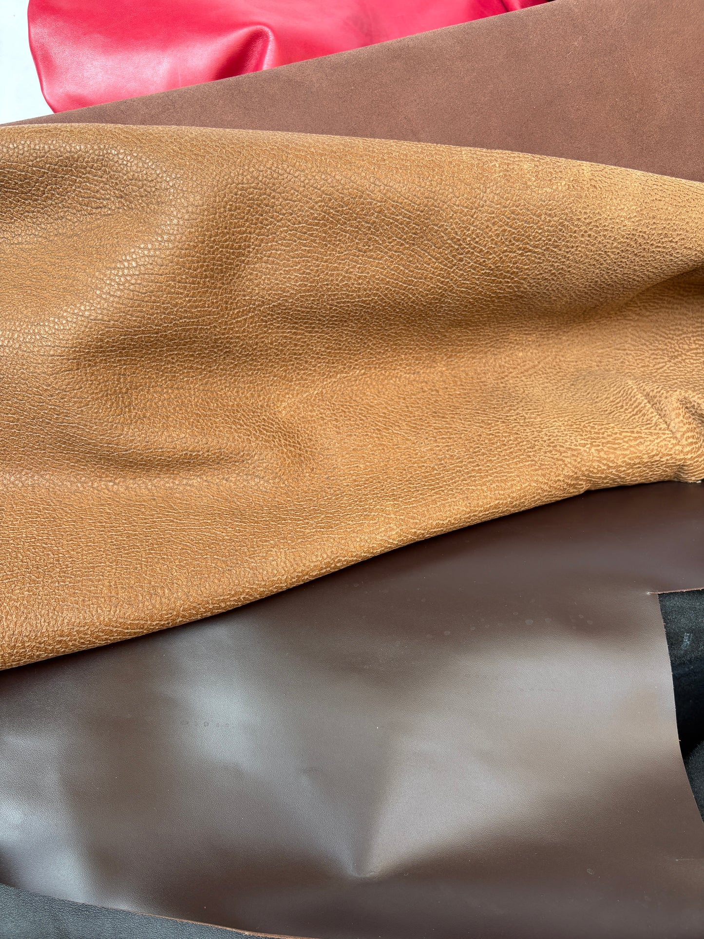 Close-up of leather textures in brown, red, and beige.