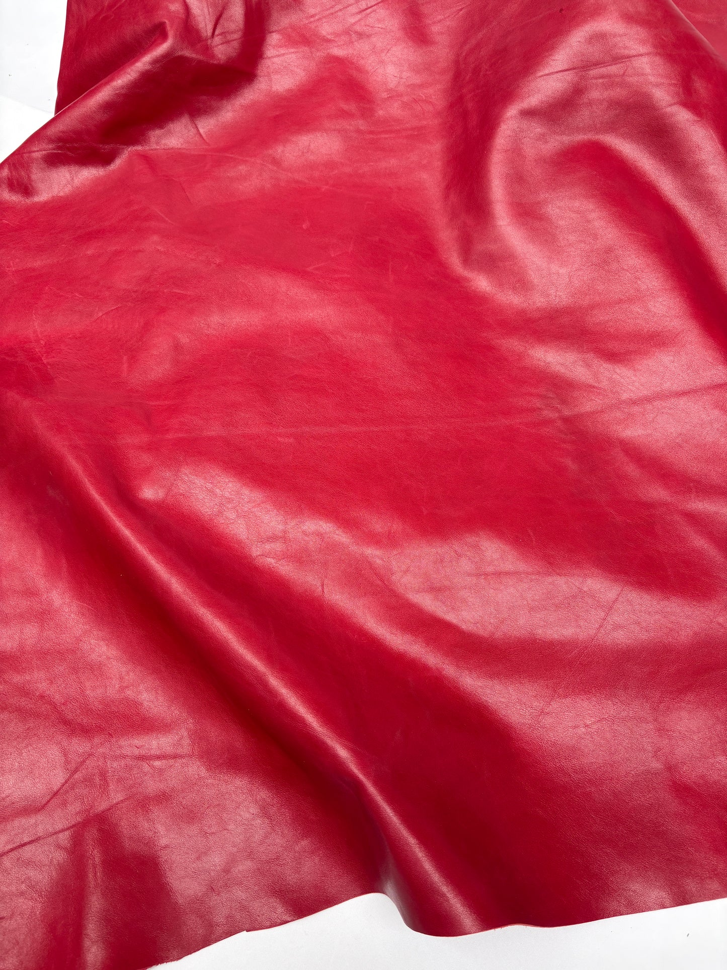 Close-up of red leather with visible texture on white background