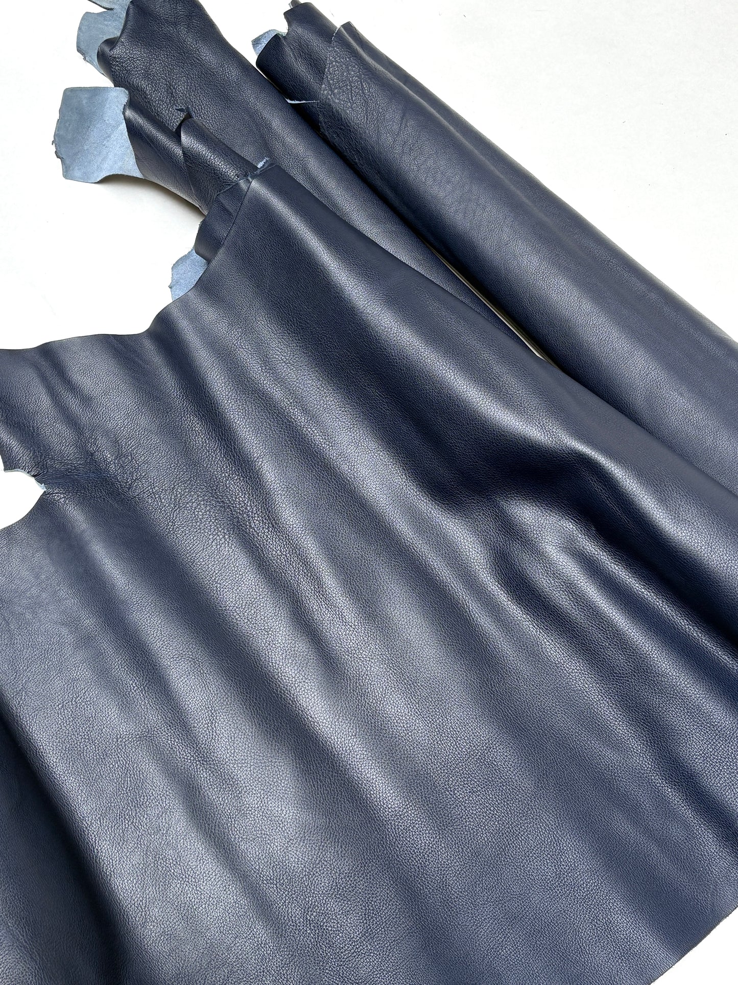 Blue leather hide is spread out with soft natural folds