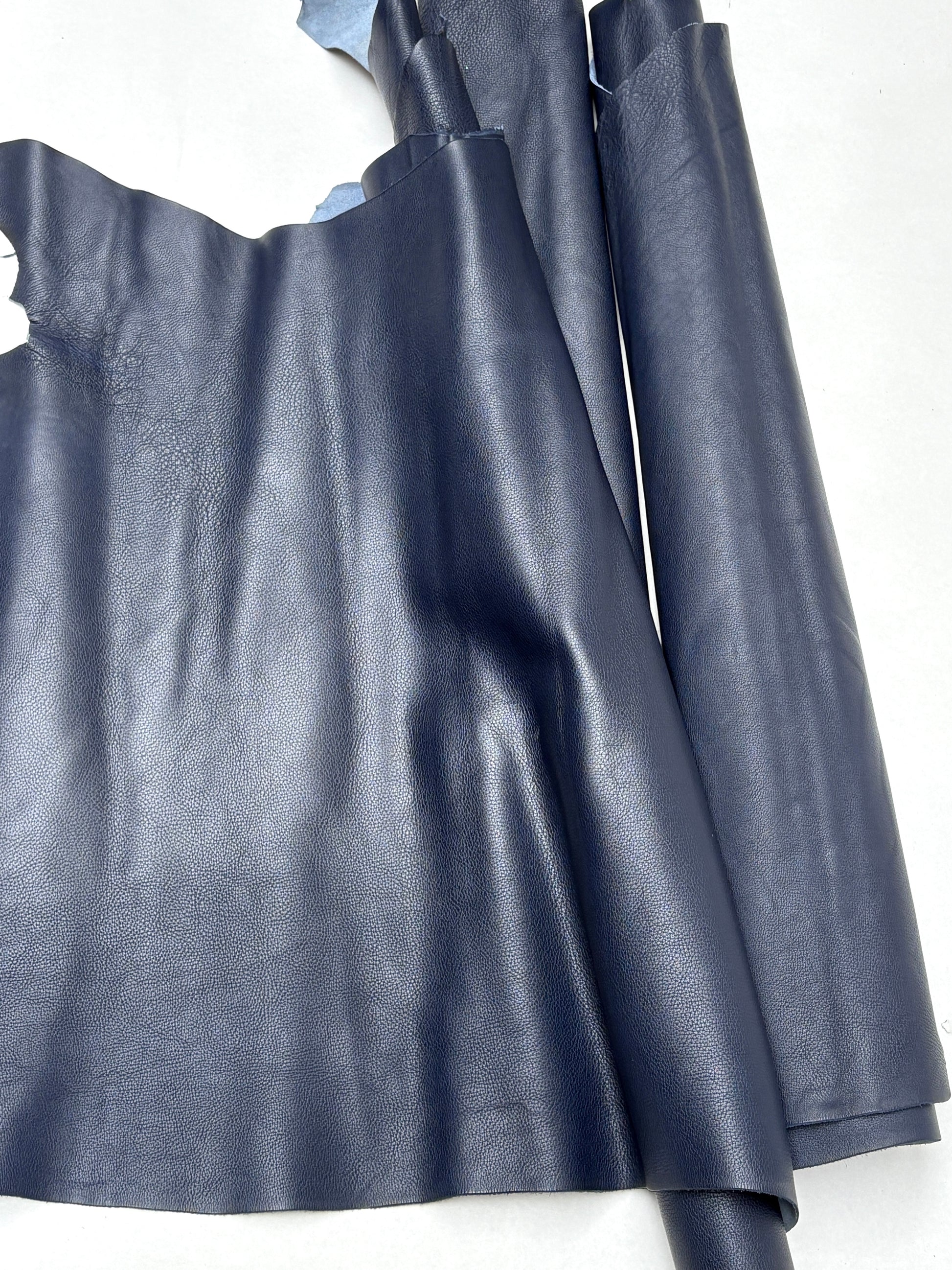 Soft blue leather hide lies flat with uneven edges
