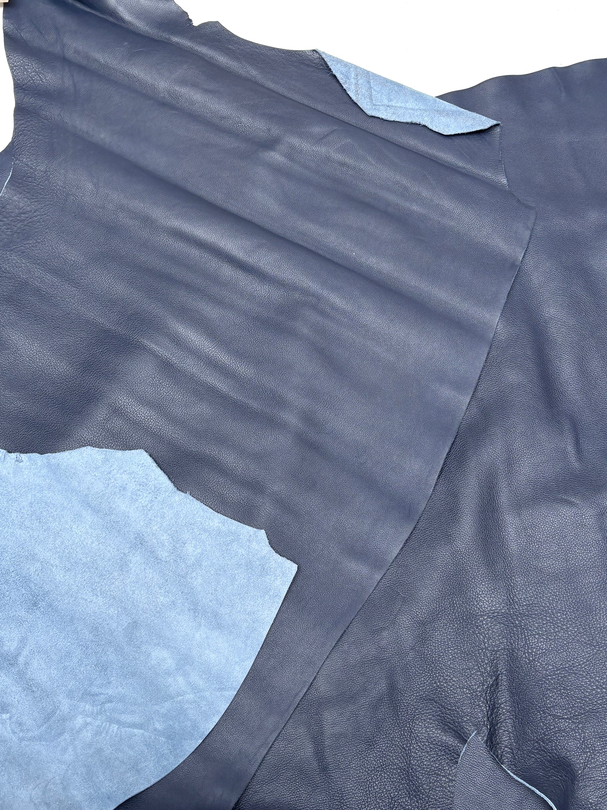 Blue leather surface is shown with fine natural creases