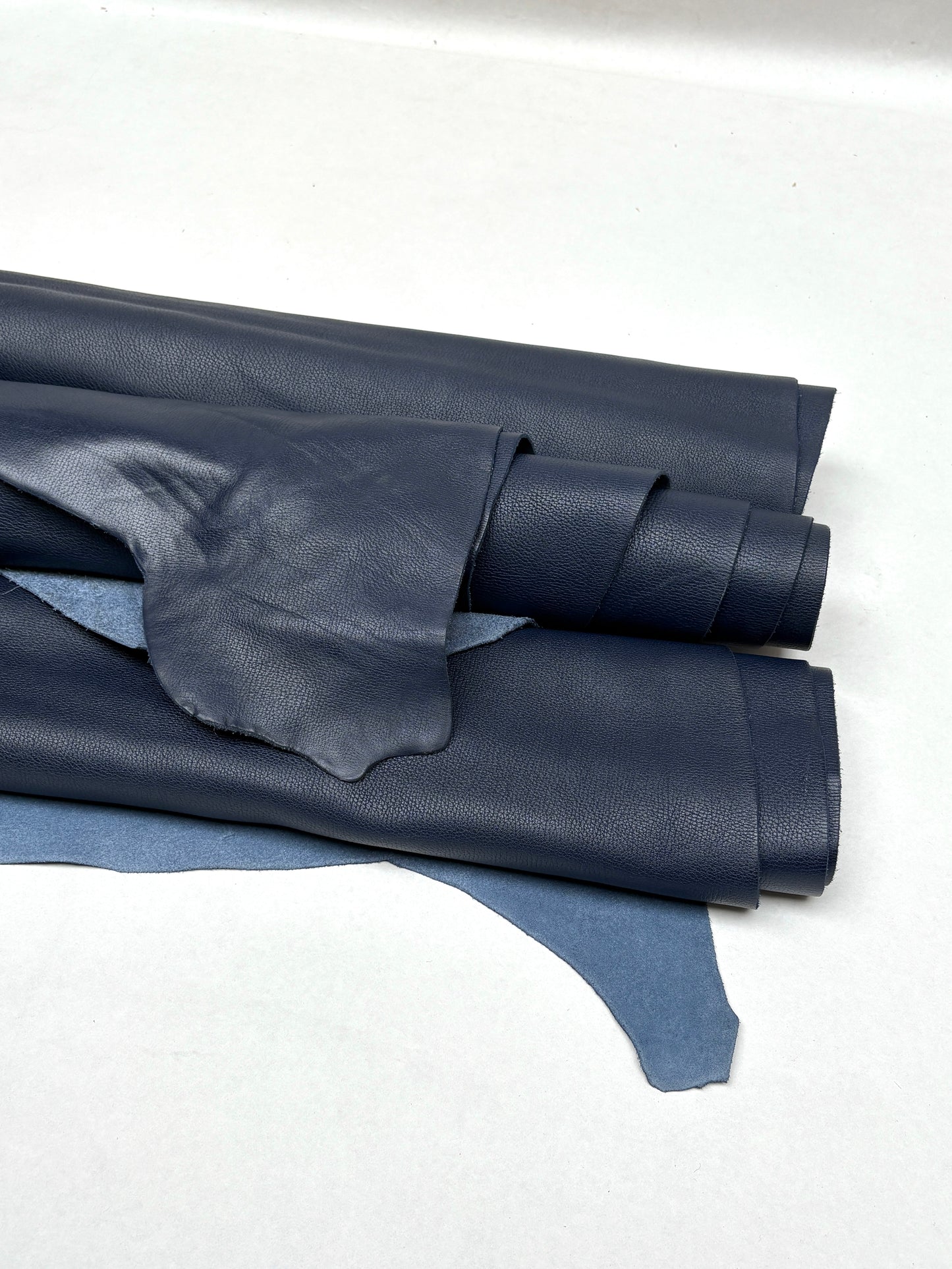 Rolled blue leather is shown with visible grain texture