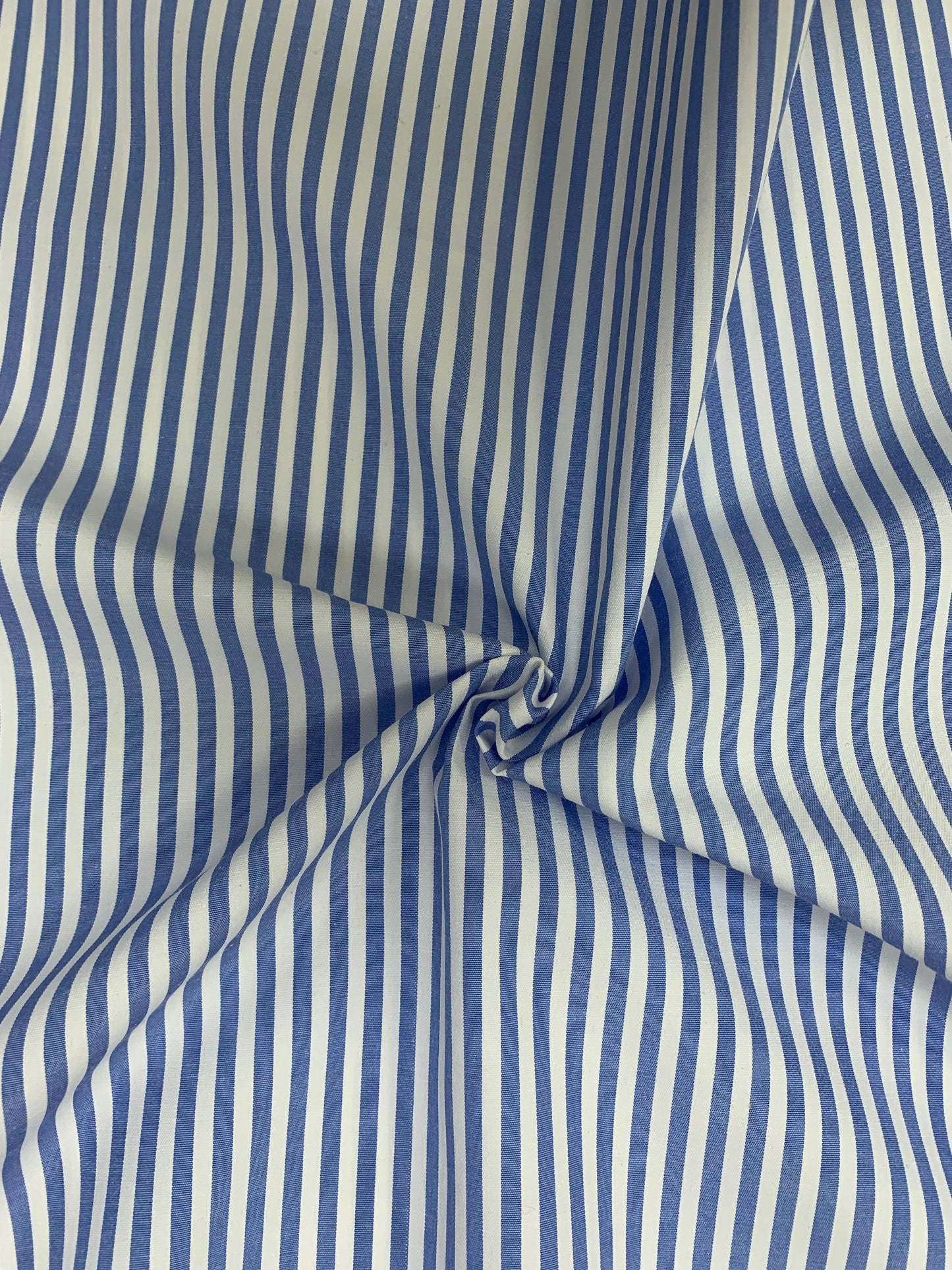 Light blue and white striped shirting fabric in soft folded detail.