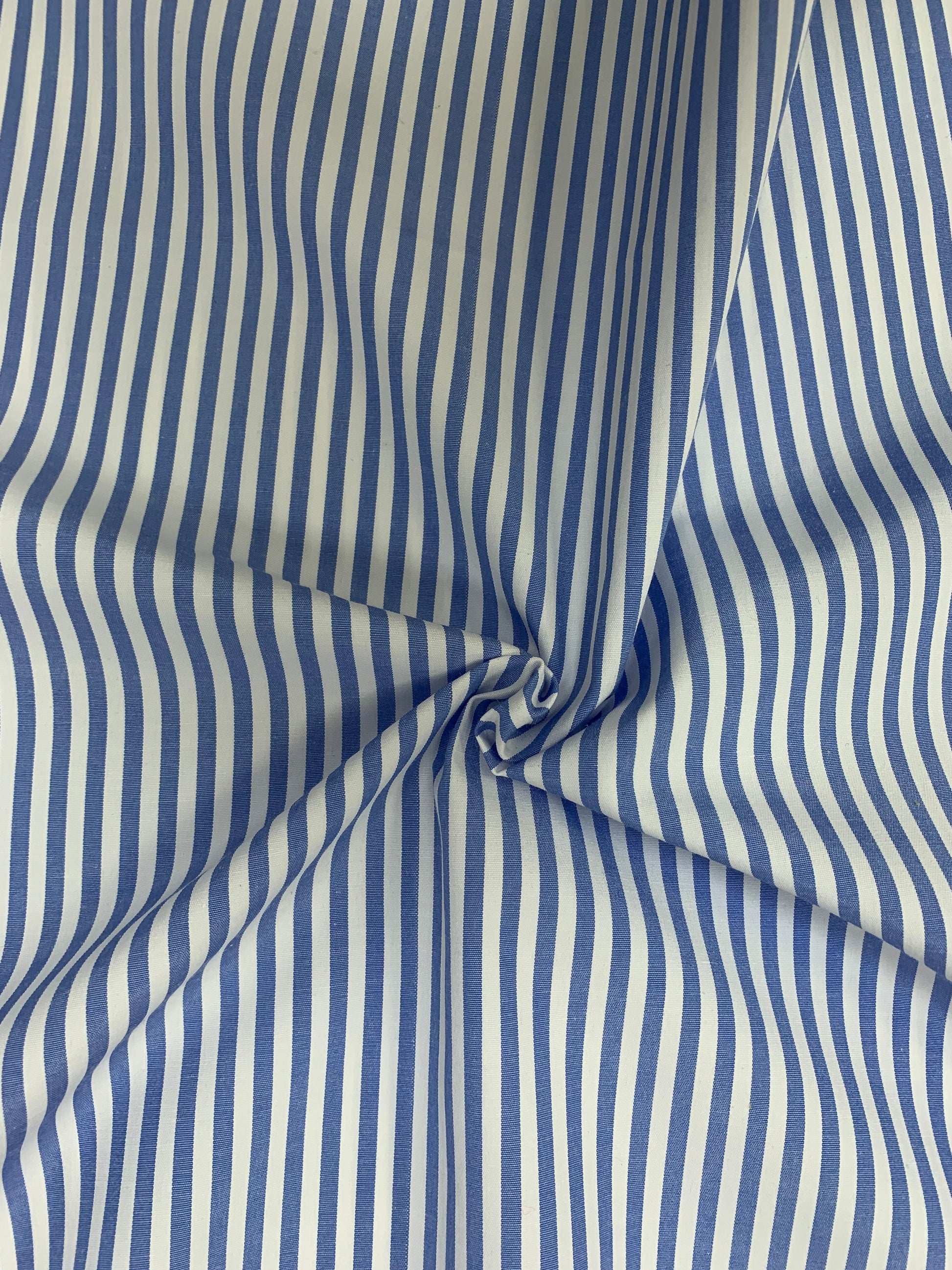 Light blue and white striped shirting fabric in soft folded detail.