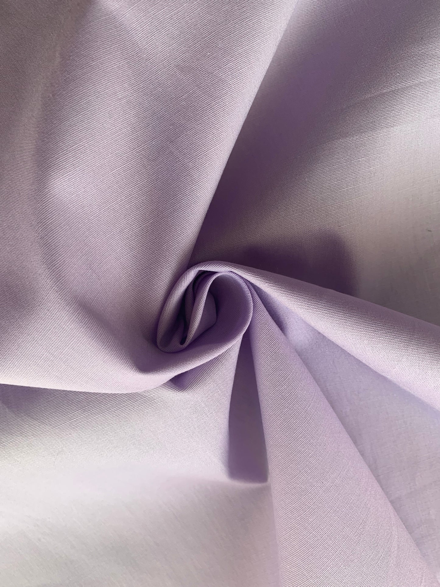 Lilac cotton fabric is folded into a soft central twist