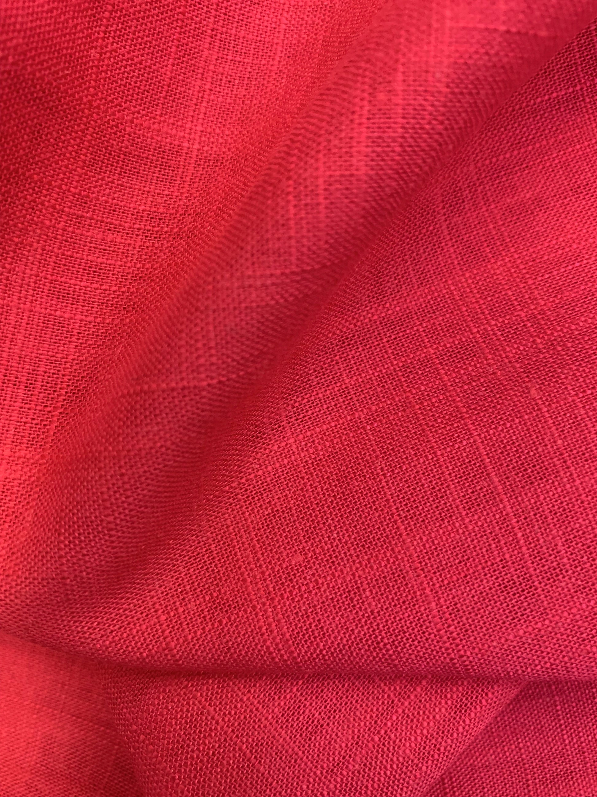 A soft draped view of lipstick pink viscose linen deadstock fabric.