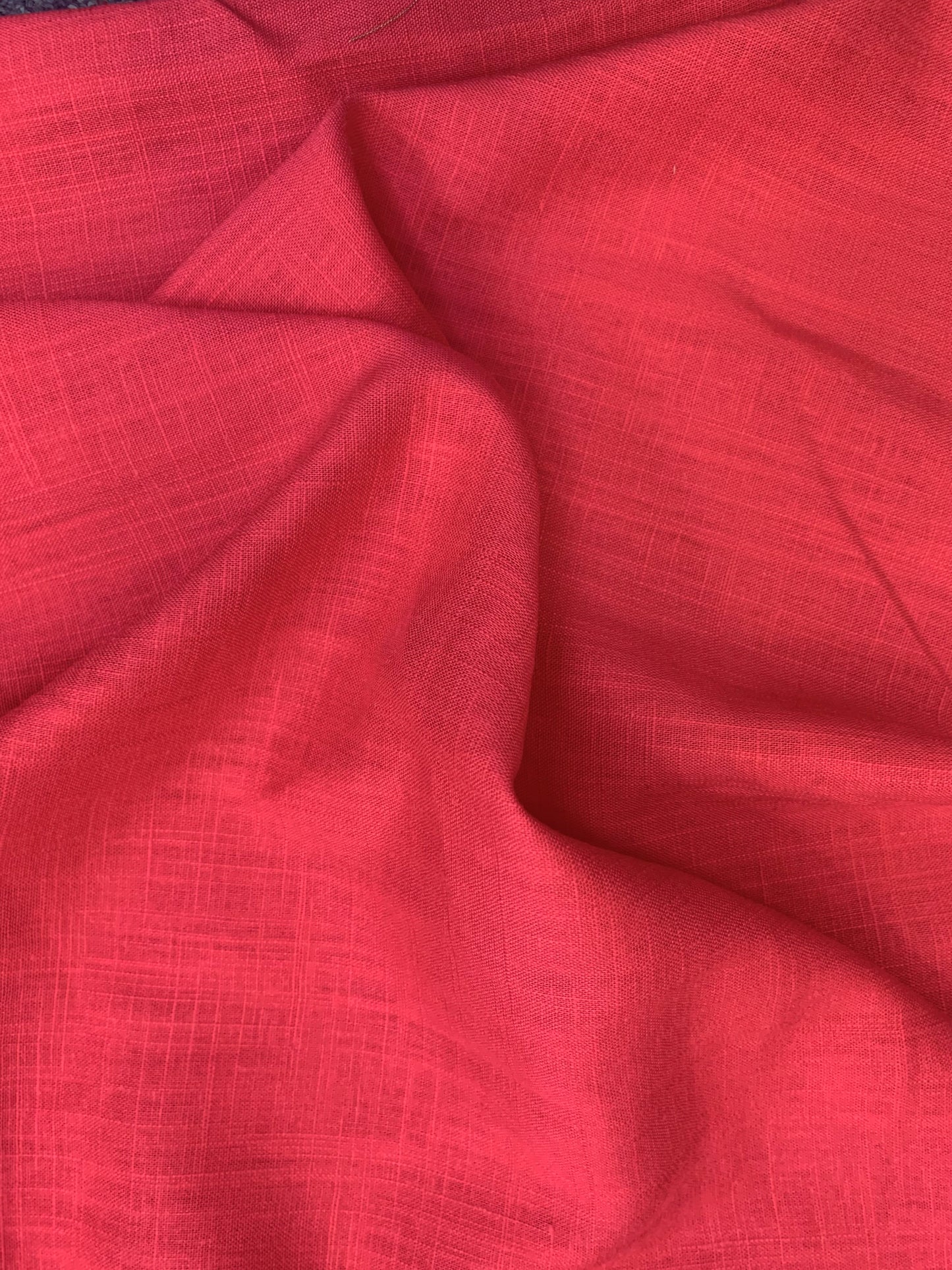 Lipstick pink viscose linen deadstock fabric gathered to show its fluid movement.