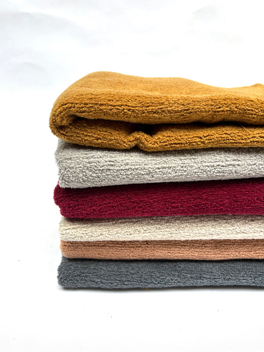 	Folded fabric pieces are stacked in a neat pile on white