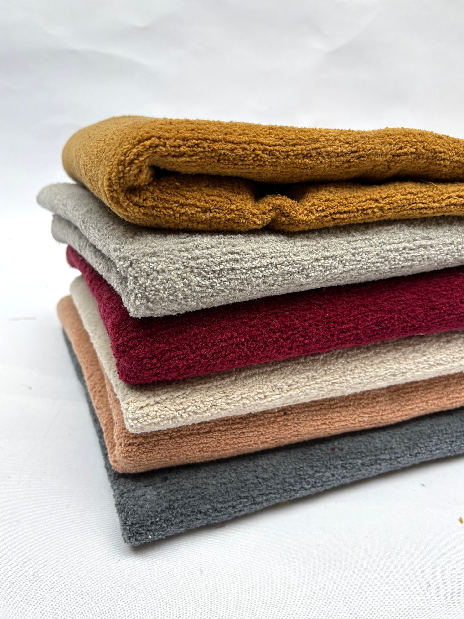	Soft folded fabric pieces are shown in a stacked arrangement on white