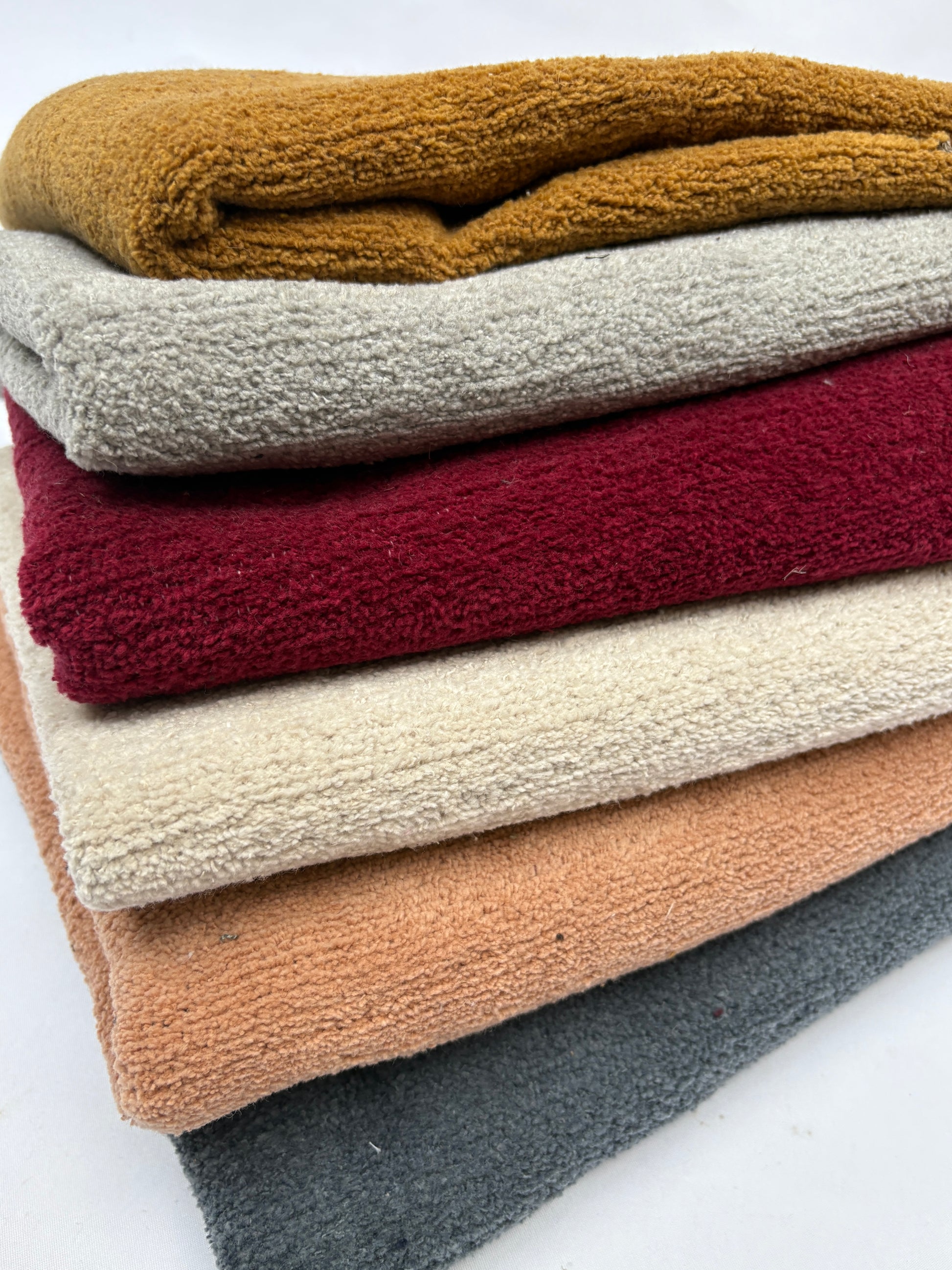 Mixed fabric pieces are stacked evenly with visible folded edges
