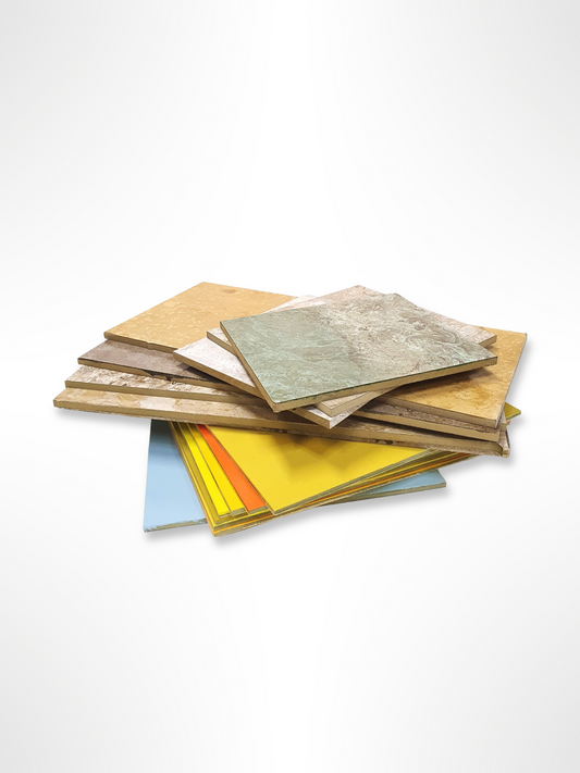 A stack of various colored MDF boards in different sizes, some with visible patterns.