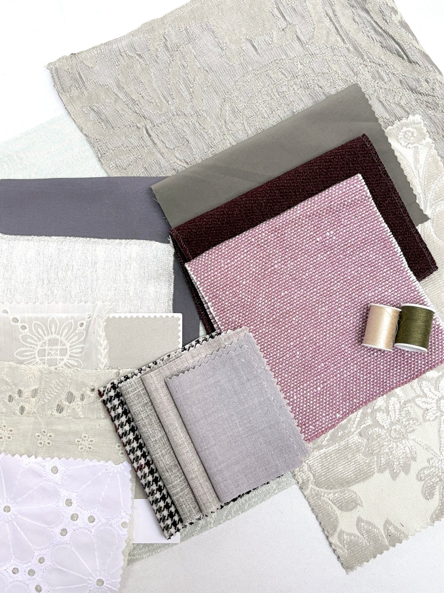 Neutral fabric swatches with lace details and matching thread spools.