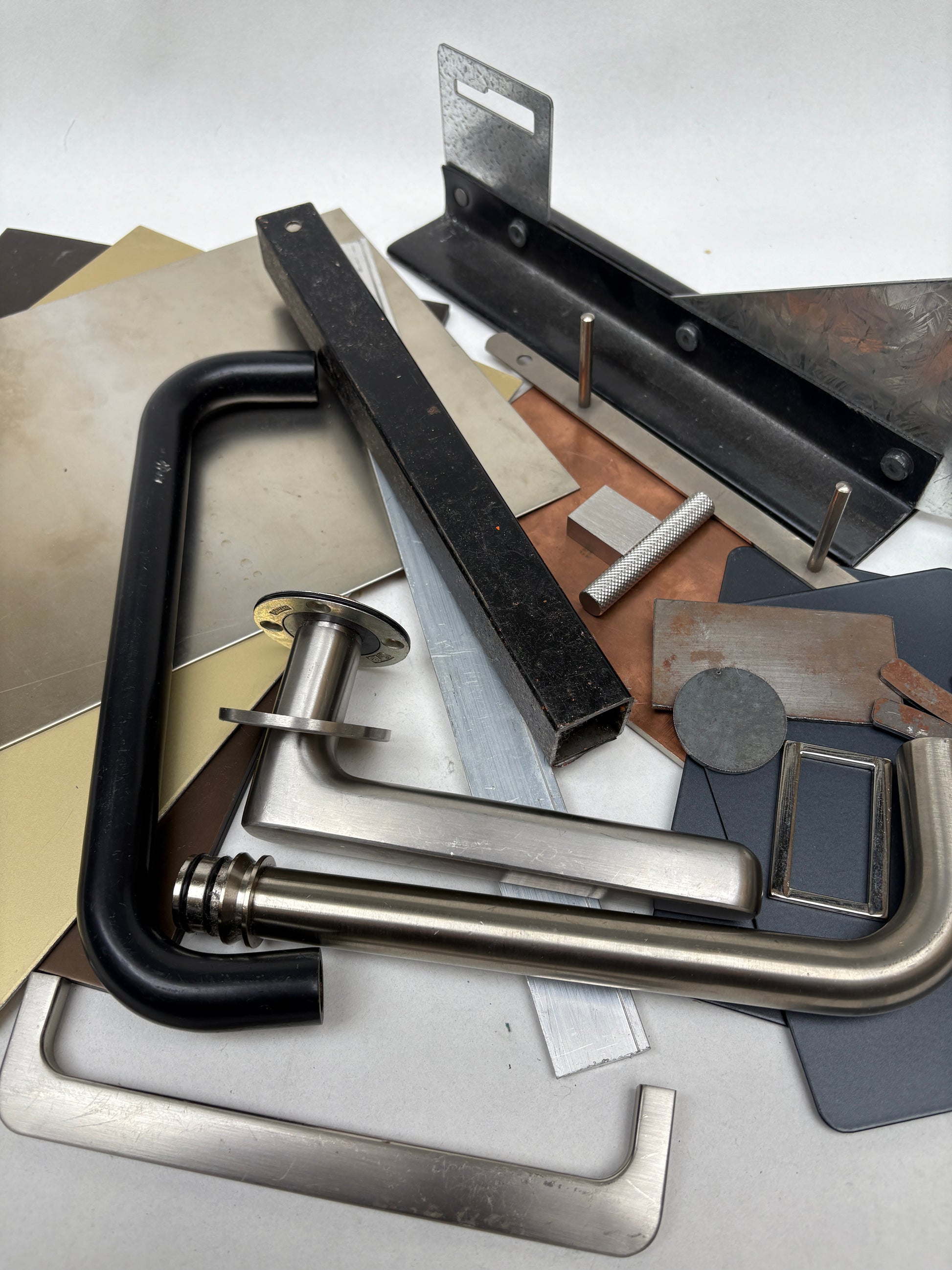 Close-up of different metal samples on a white surface